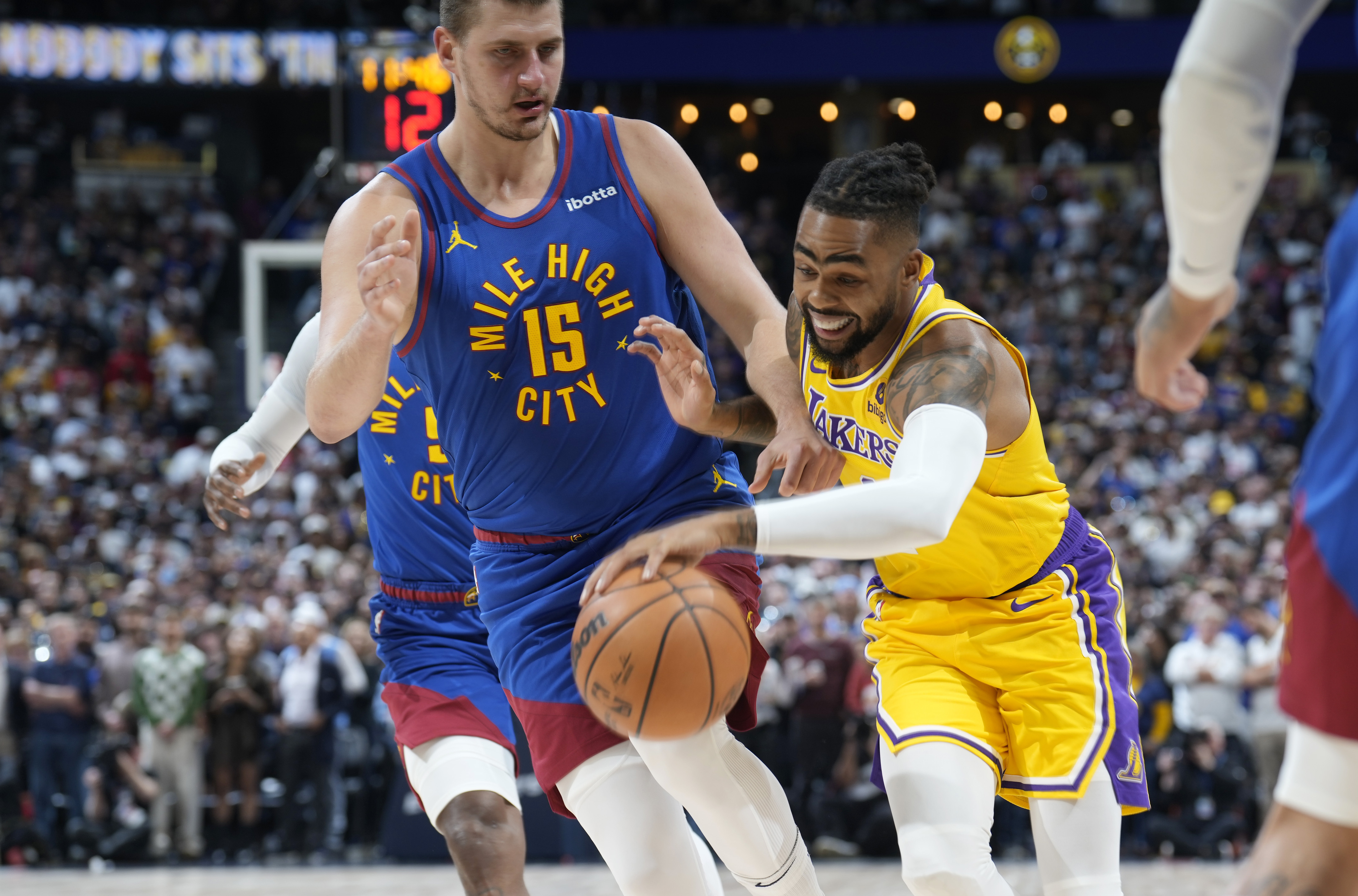 Los Angeles Lakers guard D'Angelo Russell, right, drives against Denver Nuggets center Nikola Jokic during the first half of an NBA basketball game Tuesday, Oct. 24, 2023, in Denver. (AP Photo/David Zalubowski)