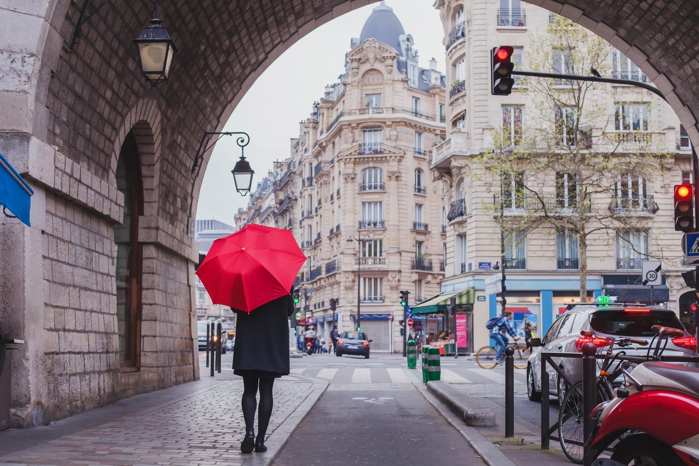 woman with red umbrella walking on the street of Paris, France