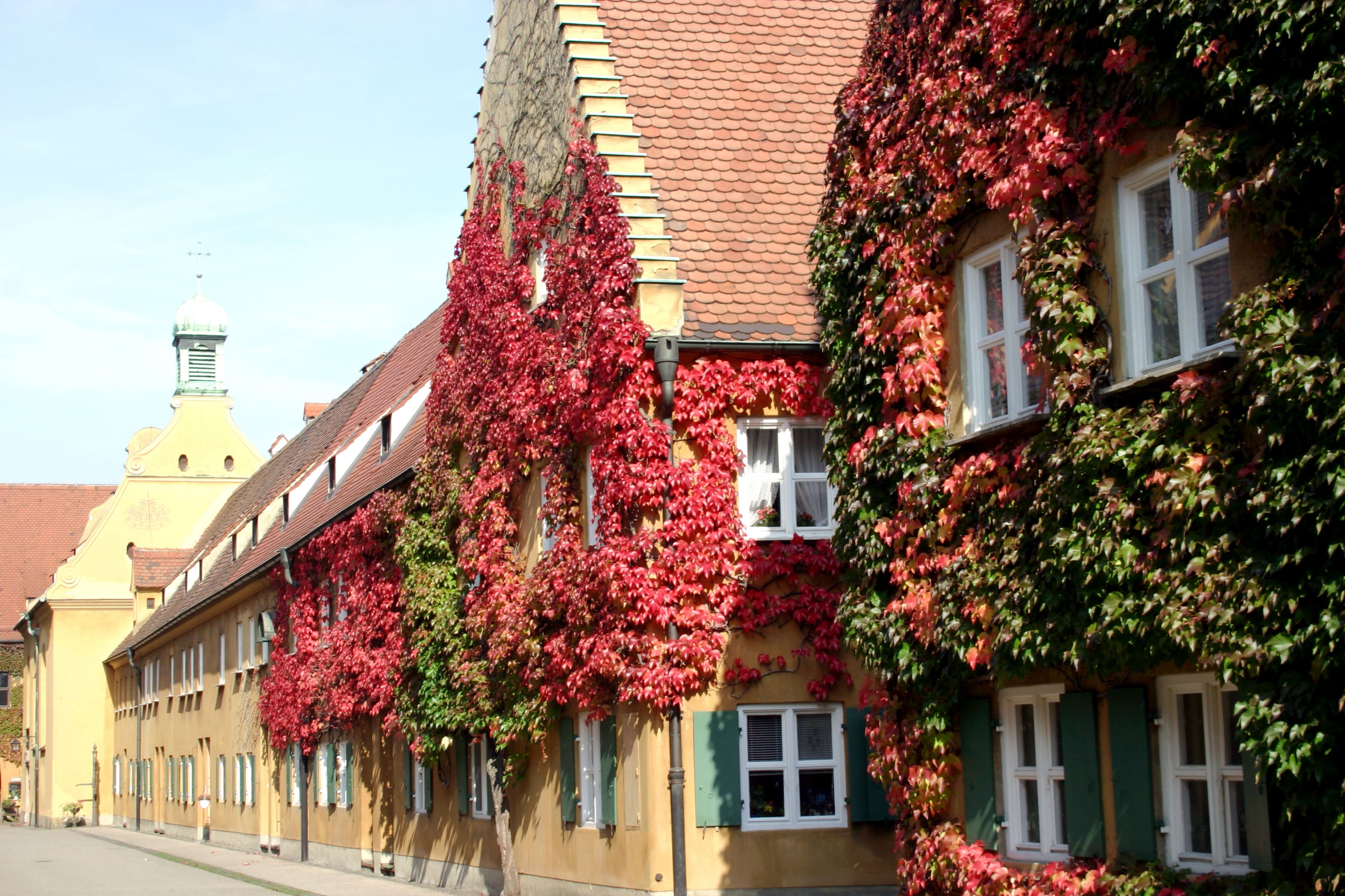 overgrown quaint houses at the Fuggerei oldest social settlement in the world Augsburg Bavaria Germany