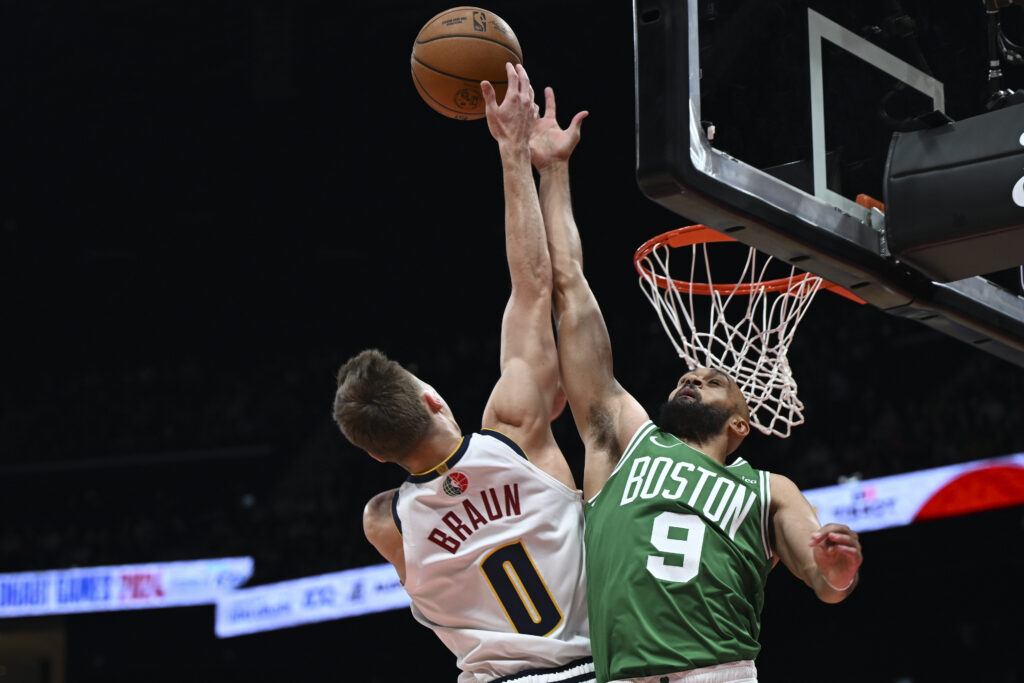 Boston Celtics Derrick White blocks Denver Nuggets Christian Braun during a preseason game between Boston Celtics and Denver Nuggets in Abu Dhabi, United Arab Emirates, Friday, Oct. 4, 2024. (AP Photo/Martin Dokoupil)
