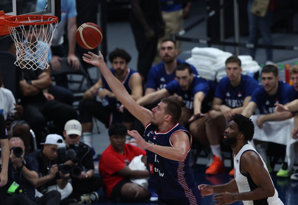 epa11483988 Nikola Jokic (L) of Serbia and Joel Embiid (R ) of the USA in action during the 2024 USA Basketball Showcase game between USA and Serbia in Abu Dhabi, United Arab Emirates, 17 July 2024.  EPA-EFE/ALI HAIDER