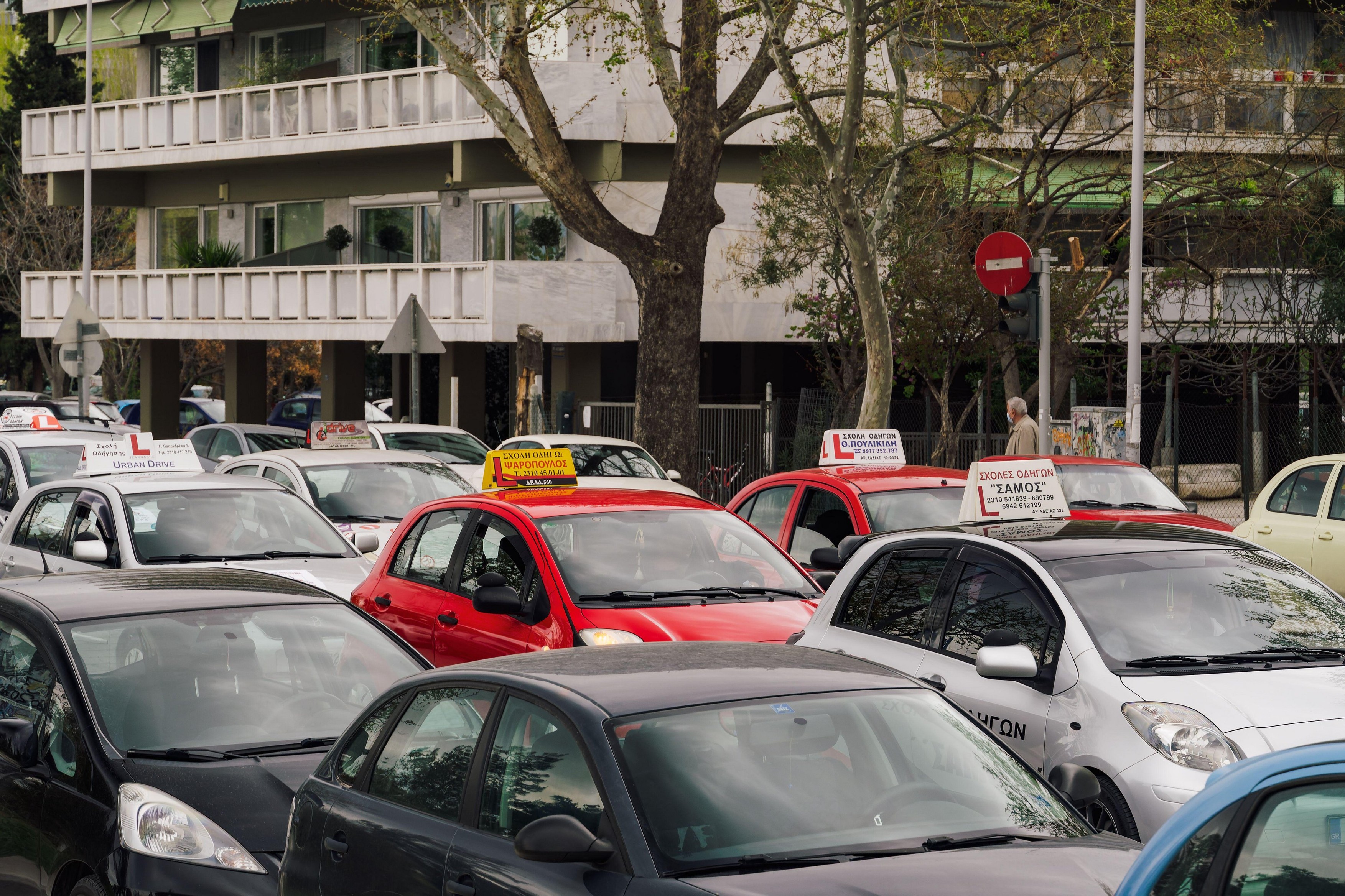 Thessaloniki, Greece driving school vehicles marching on a central city road. Stopped cars with Learner sign and drivers inside demonstrating to protect the future of their occupation