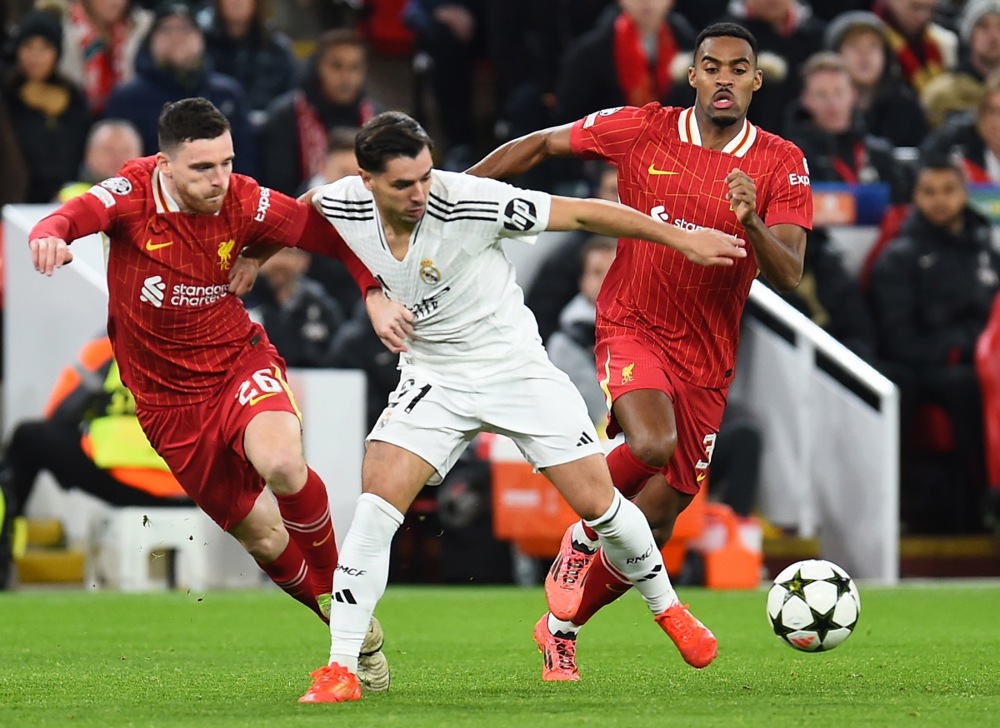 epa11744346 Andrew Robertson (L) and Ryan Gravenberch of Liverpool in action against Brahim Diaz (C) of Real Madrid during the UEFA Champions League match between Liverpool and Real Madrid in Liverpool, Britain, 27 November 2024.  EPA-EFE/PETER POWELL