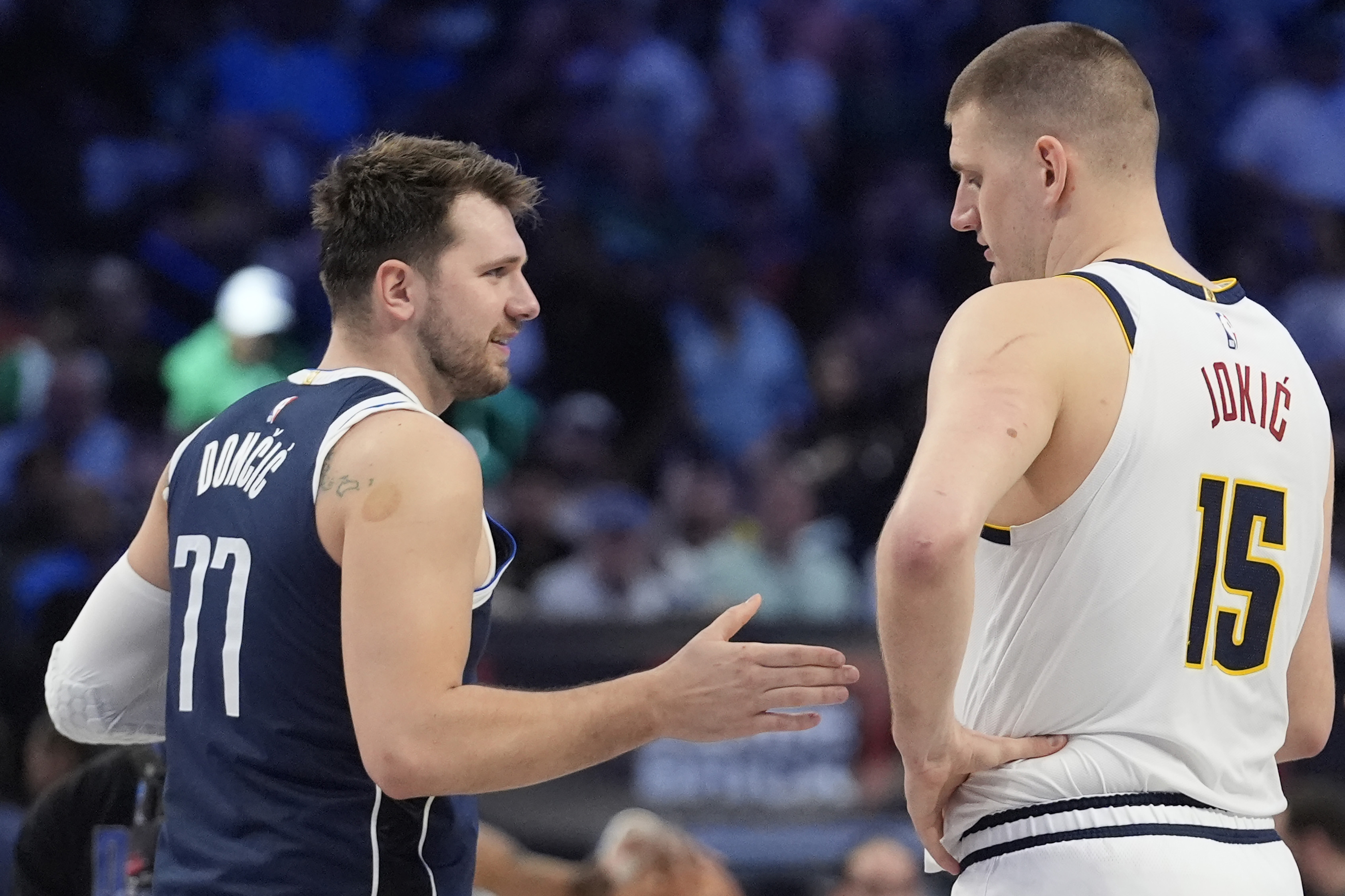 Dallas Mavericks guard Luka Doncic (77) offers his hand to shake with Denver Nuggets center Nikola Jokic (15) before the start of the first half of an NBA basketball game in Dallas, Sunday, March 17, 2024. (AP Photo/LM Otero)