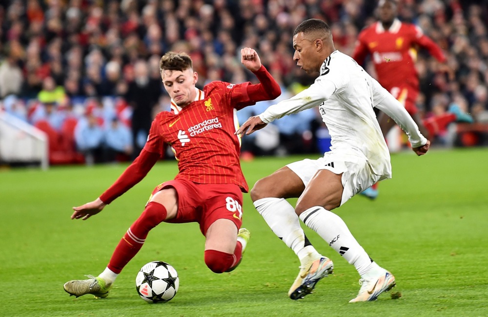 epa11744440 Conor Bradley (L) of Liverpool in action against Kylian Mbappe of Real Madrid during the UEFA Champions League match between Liverpool and Real Madrid in Liverpool, Britain, 27 November 2024.  EPA-EFE/PETER POWELL