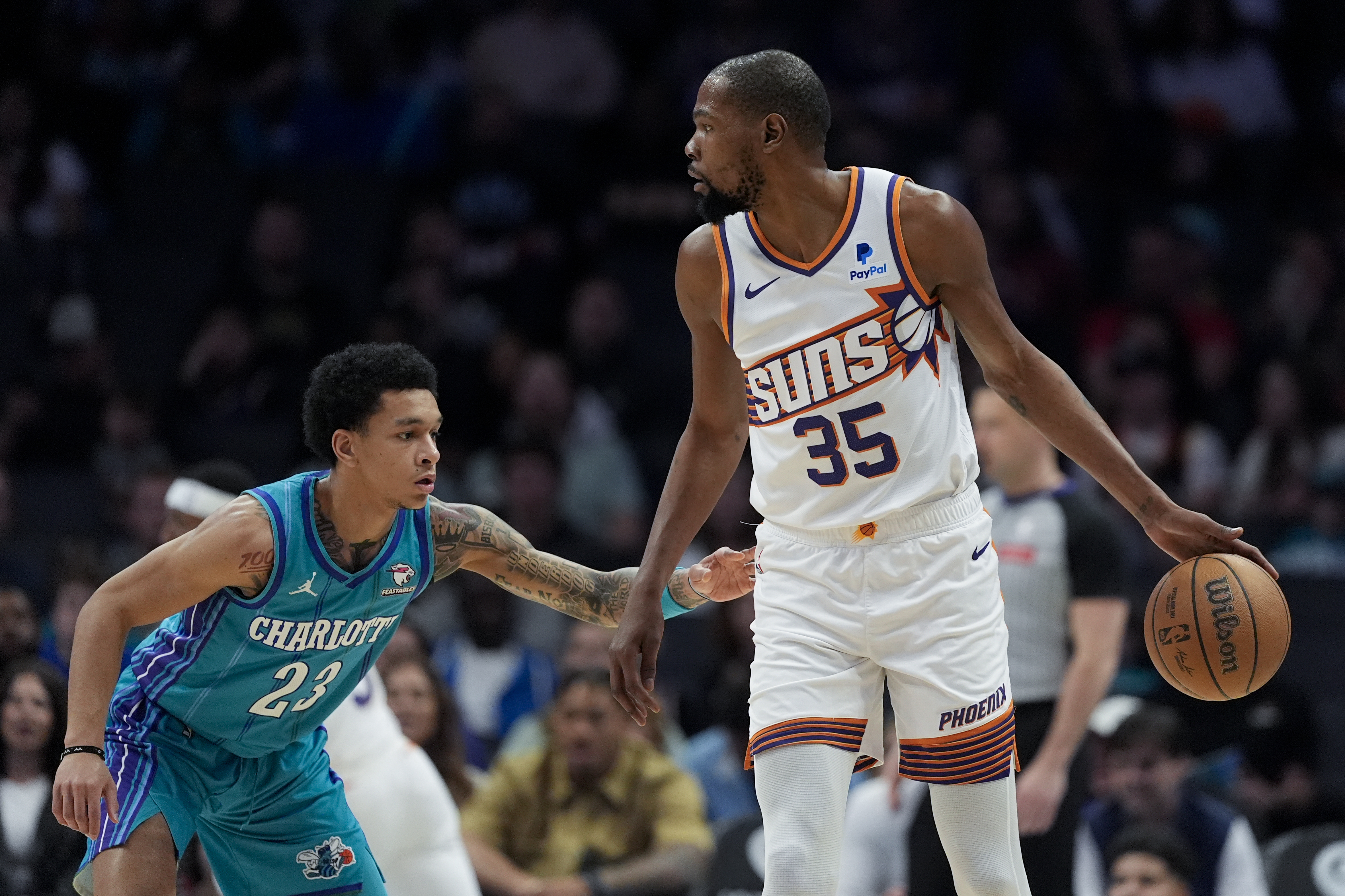 Phoenix Suns forward Kevin Durant is guarded by Charlotte Hornets guard Tre Mann during the first half of an NBA basketball game on Friday, March 15, 2024, in Charlotte, N.C. (AP Photo/Chris Carlson)