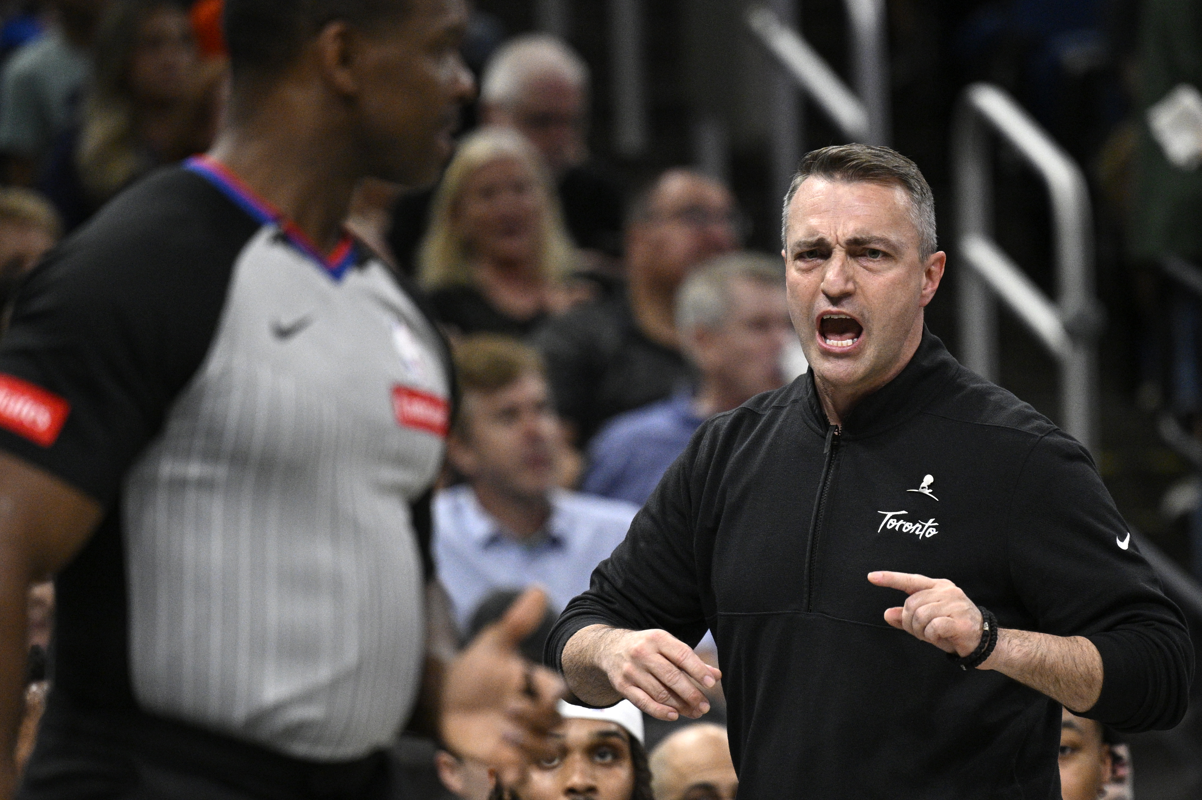 Toronto Raptors head coach Darko Rajakovic, right, argues with official Dedric Taylor during the first half of an NBA basketball game against the Orlando Magic, Sunday, March 17, 2024, in Orlando, Fla. (AP Photo/Phelan M. Ebenhack)