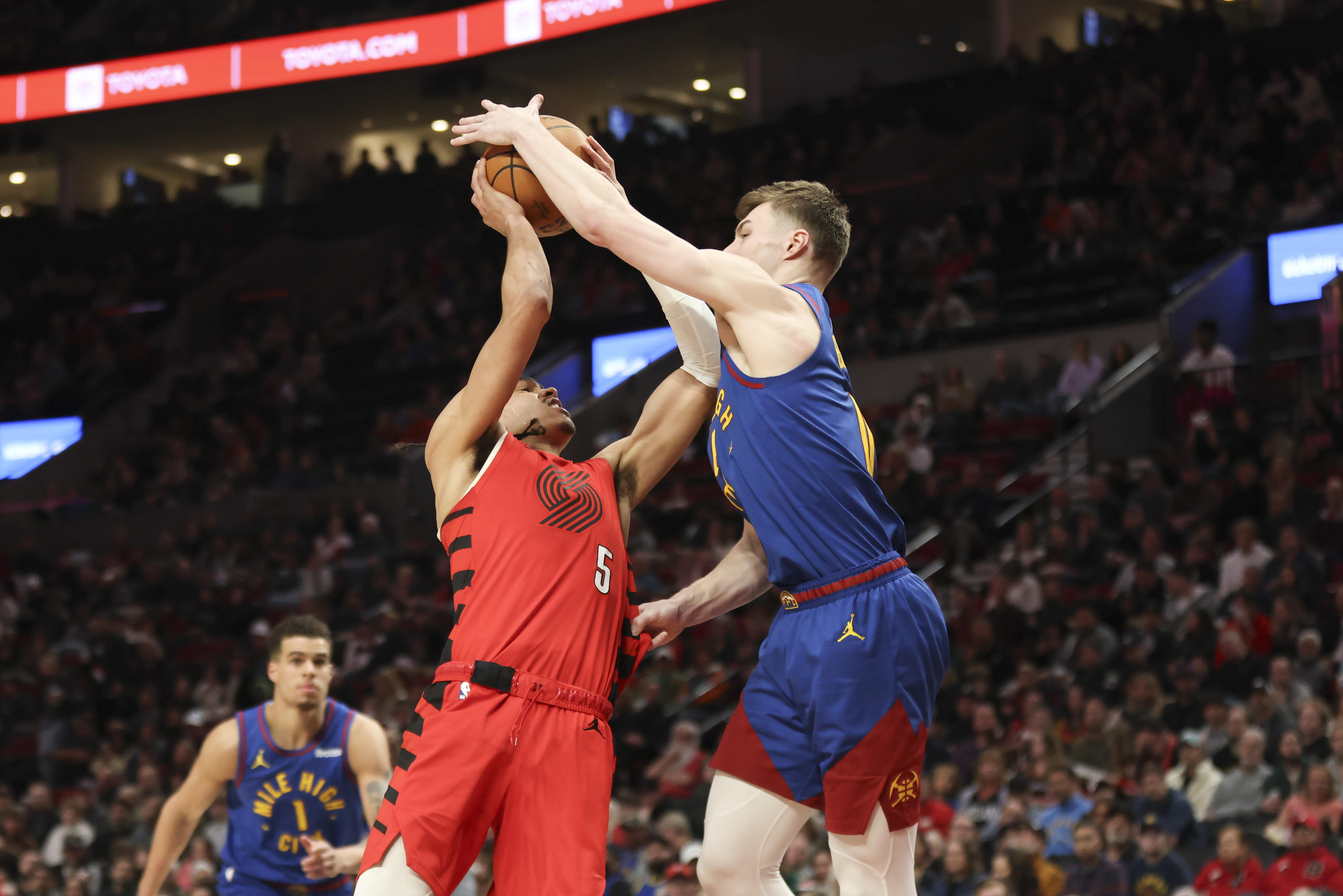 Denver Nuggets guard Christian Braun, right, blocks a shot by Portland Trail Blazers guard Dalano Banton (5) during the second half of an NBA basketball game Saturday, March 23, 2024, in Portland, Ore. (AP Photo/Amanda Loman)