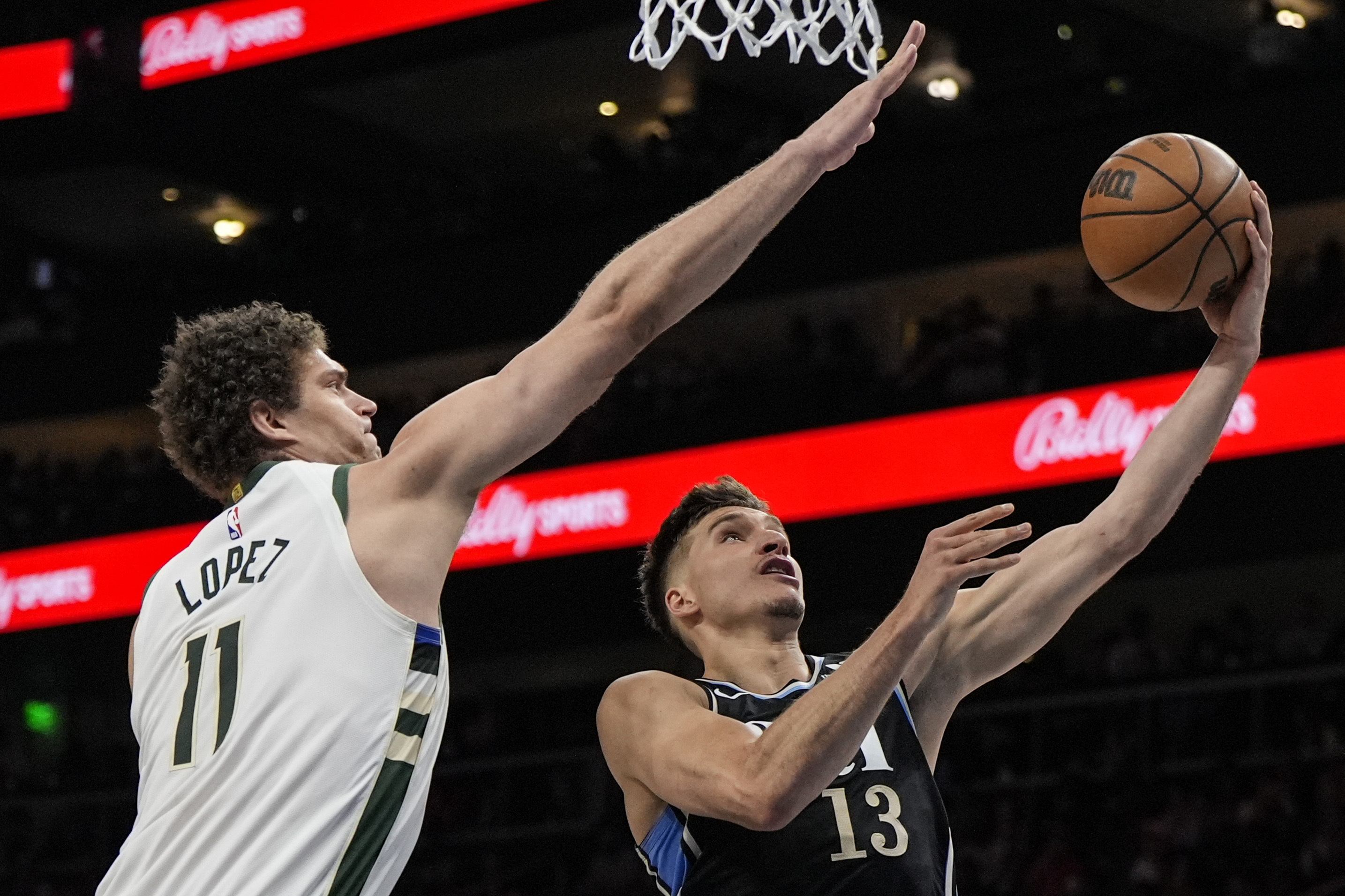 Atlanta Hawks guard Bogdan Bogdanovic (13) drives against Milwaukee Bucks center Brook Lopez (11) during the first half of an NBA basketball game, Saturday, March 30, 2024, in Atlanta. (AP Photo/Mike Stewart)