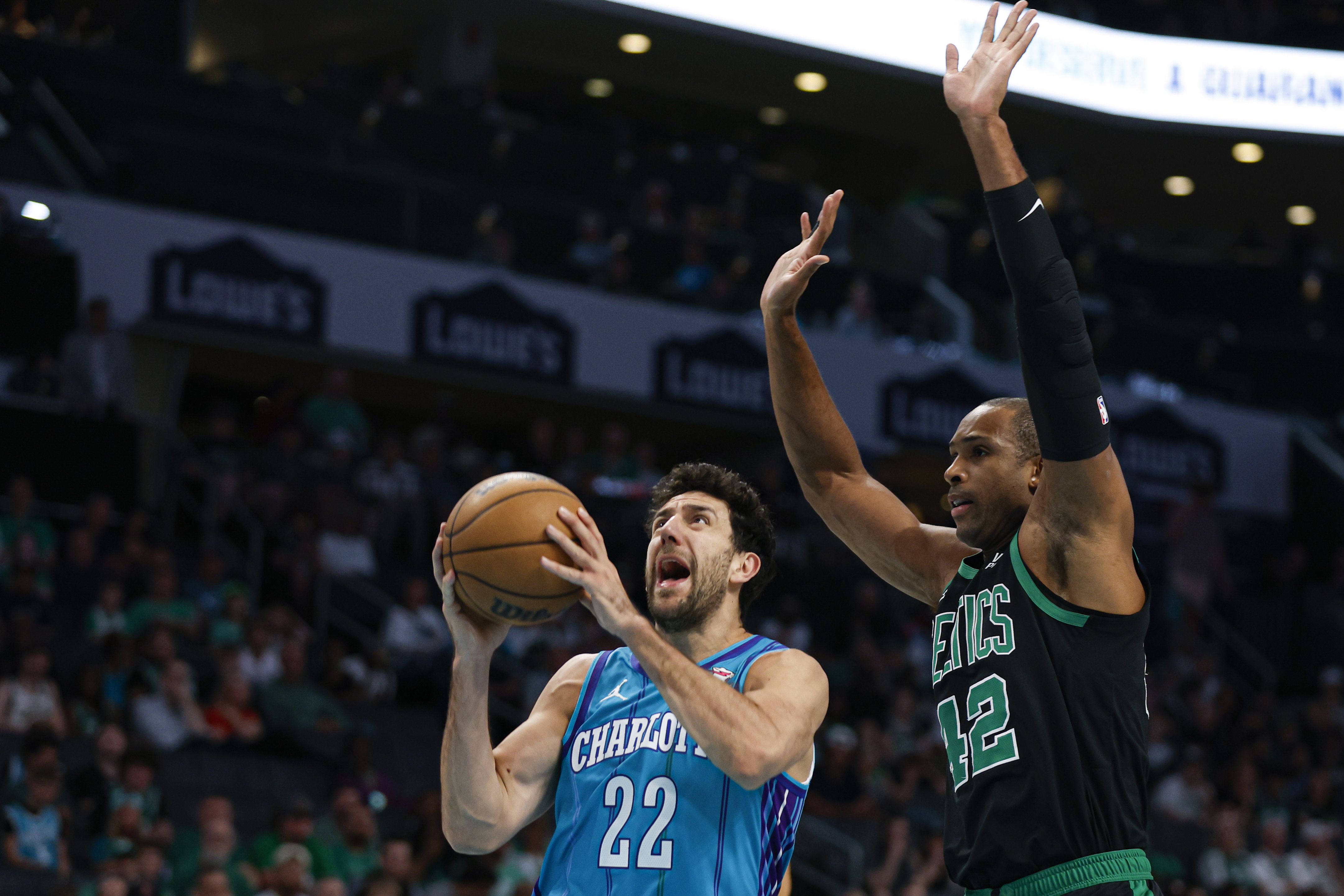 Charlotte Hornets guard Vasa Micic (22) drives to the basket ahead of Boston Celtics center Al Horford (42) during the first half of an NBA basketball game in Charlotte, N.C., Monday, April 1, 2024. (AP Photo/Nell Redmond)