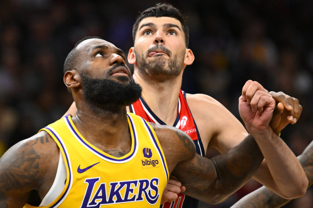 Los Angeles Lakers forward LeBron James, left, maneuvers for a rebound against Washington Wizards forward Tristan Vukcevic during the first half of an NBA basketball game Wednesday, April 3, 2024, in Washington. (AP Photo/John McDonnell)