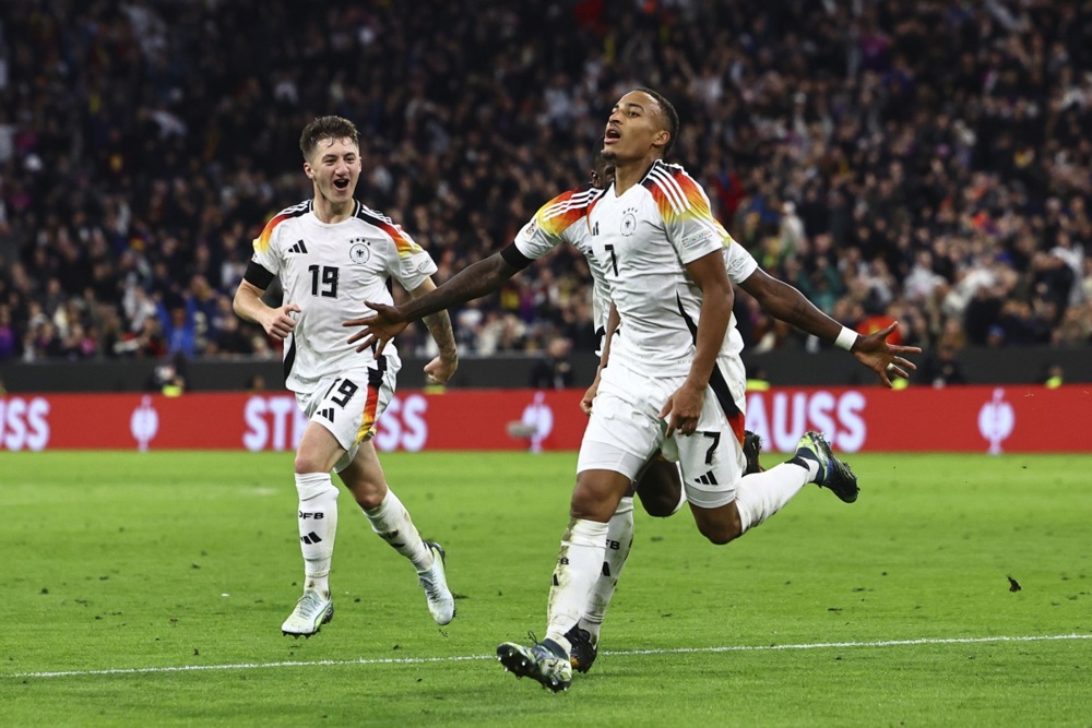 epa11659529 Jamie Leweling of Germany celebrates with teammates after scoring the 1-0 goal during the UEFA Nations League group soccer match between Germany and Netherlands, in Munich, Germany, 14 October 2024.  EPA-EFE/FILIP SINGER