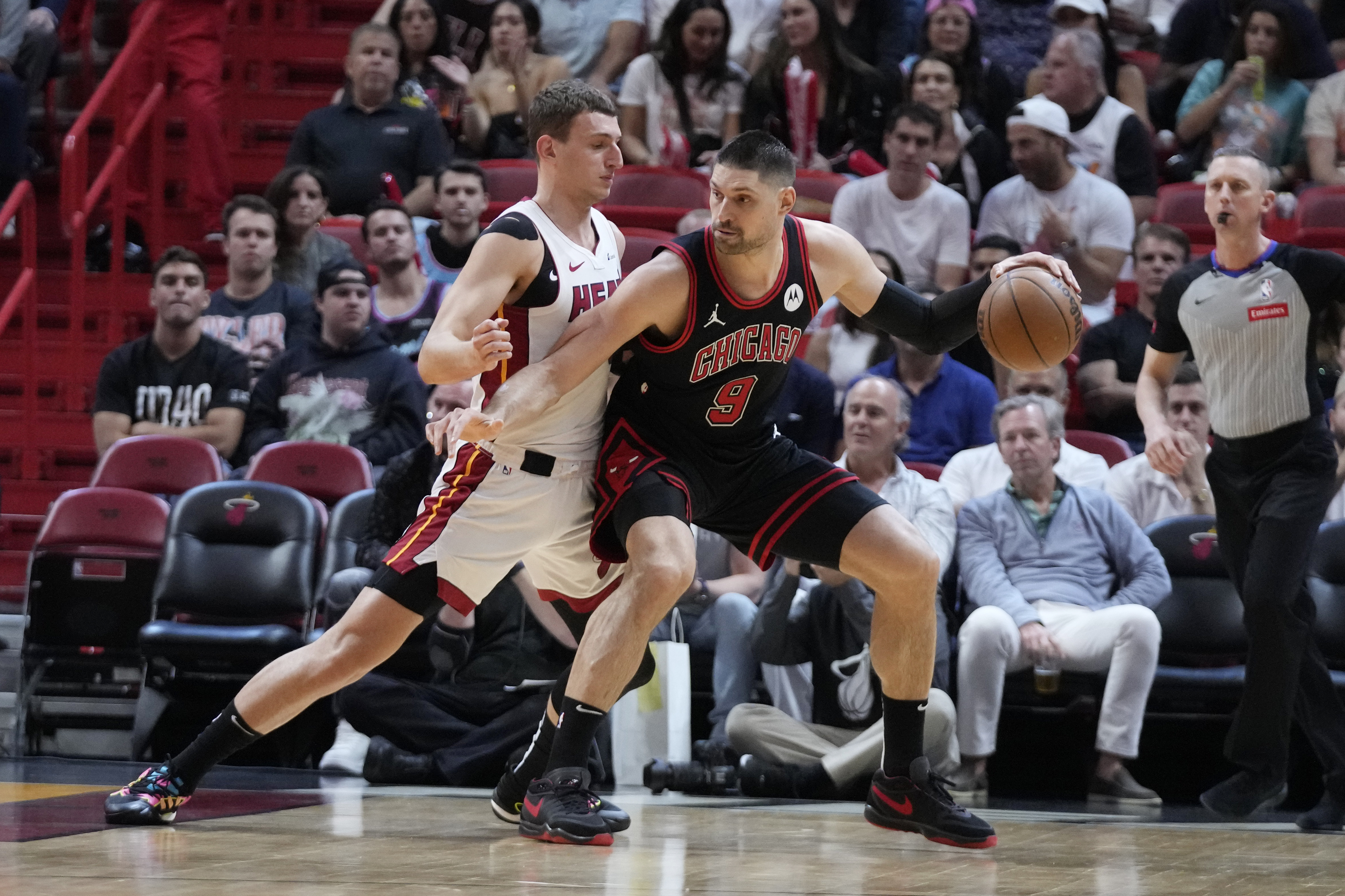 Chicago Bulls center Nikola Vucevic (9) drives up against Miami Heat forward Nikola Jovic during the first half of an NBA basketball play-in tournament game, Friday, April 19, 2024, in Miami. (AP Photo/Wilfredo Lee)