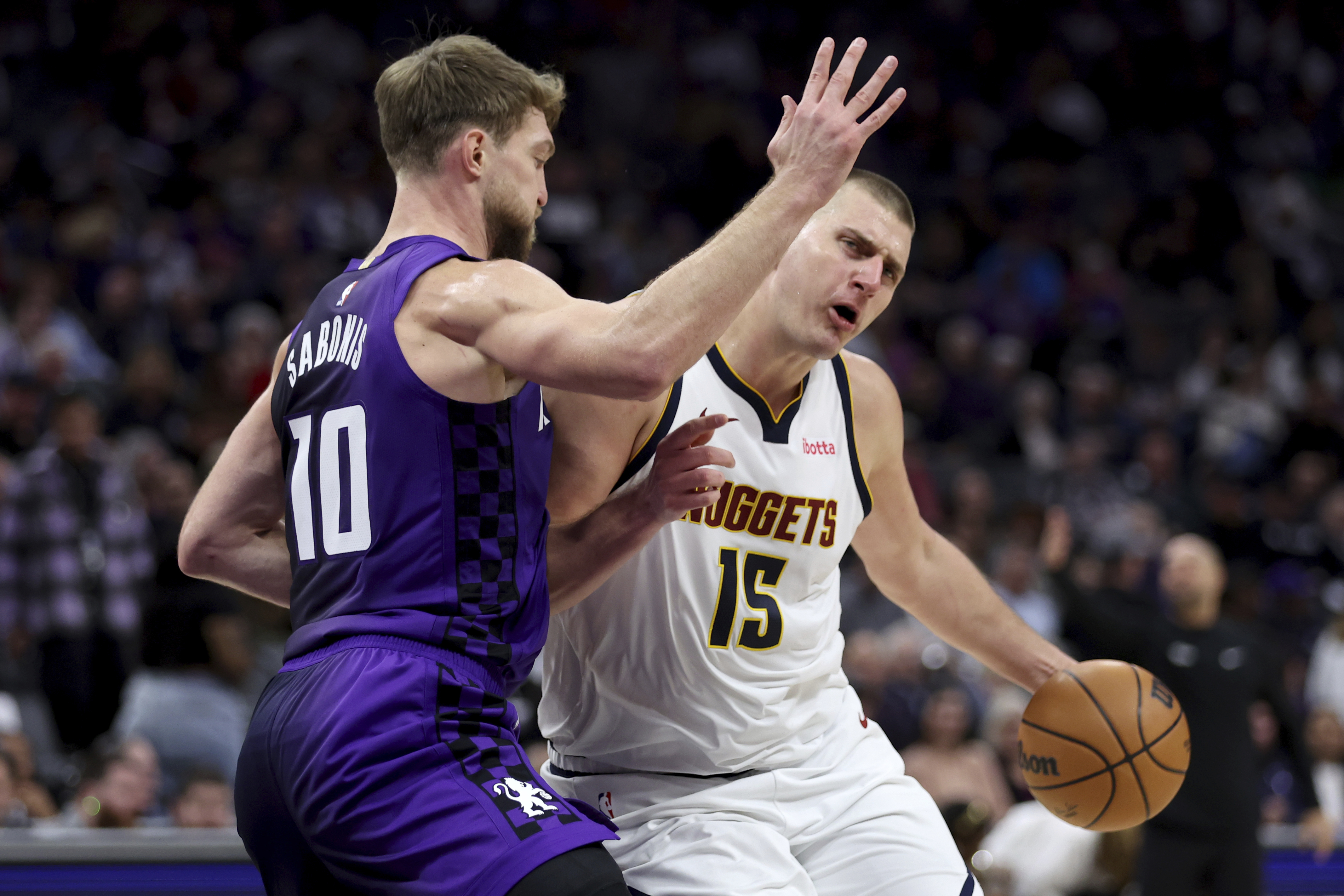Denver Nuggets center Nikola Jokic (15) drives to the basket against Sacramento Kings forward Domantas Sabonis (10) during the first half of an NBA basketball game in Sacramento, Calif, Friday, Feb. 9, 2024. (AP Photo/Jed Jacobsohn)