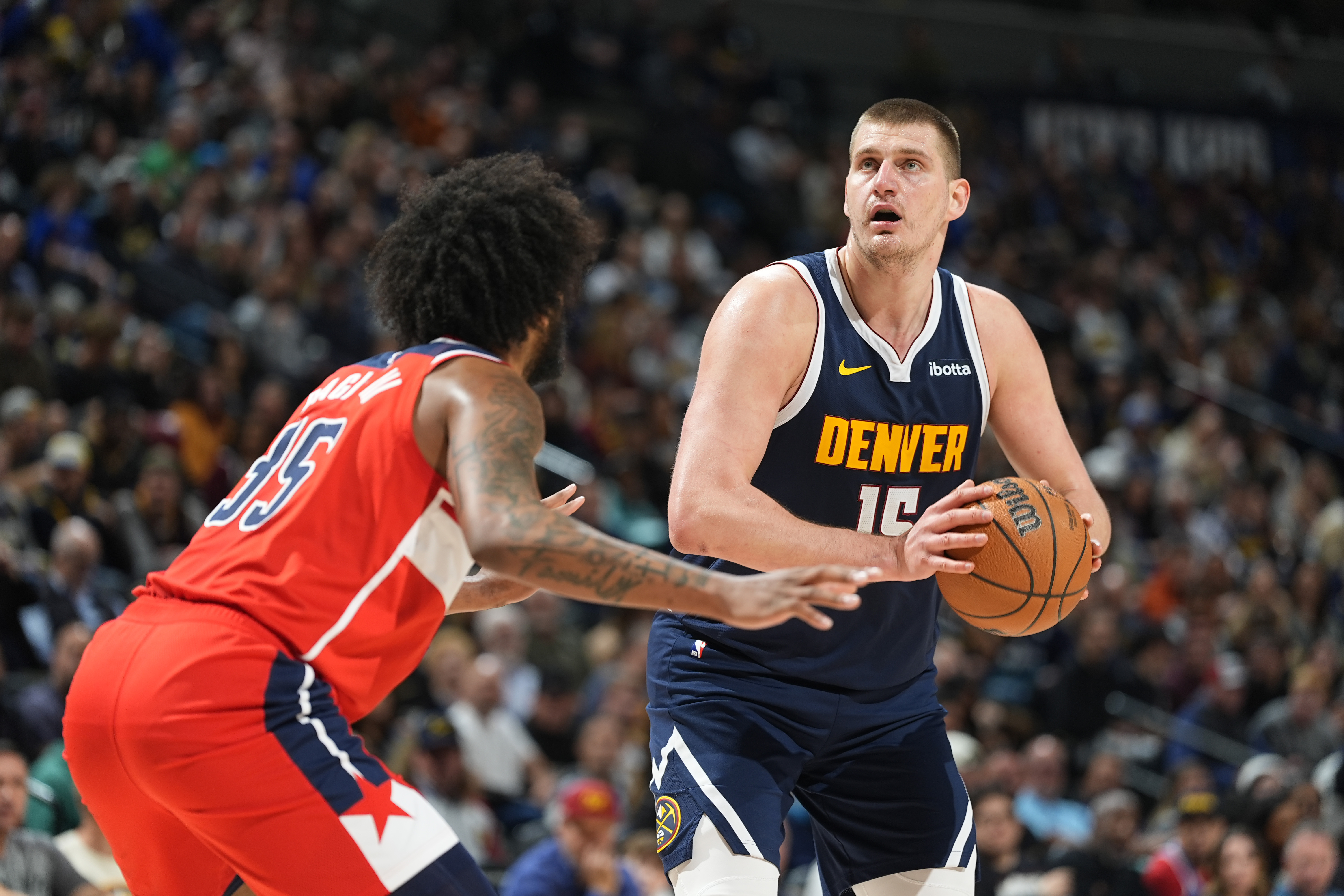 Denver Nuggets center Nikola Jokic, right, looks to shoot the ball as Washington Wizards forward Marvin Bagley III defends in the second half of an NBA basketball game Thursday, Feb. 22, 2024, in Denver. (AP Photo/David Zalubowski)