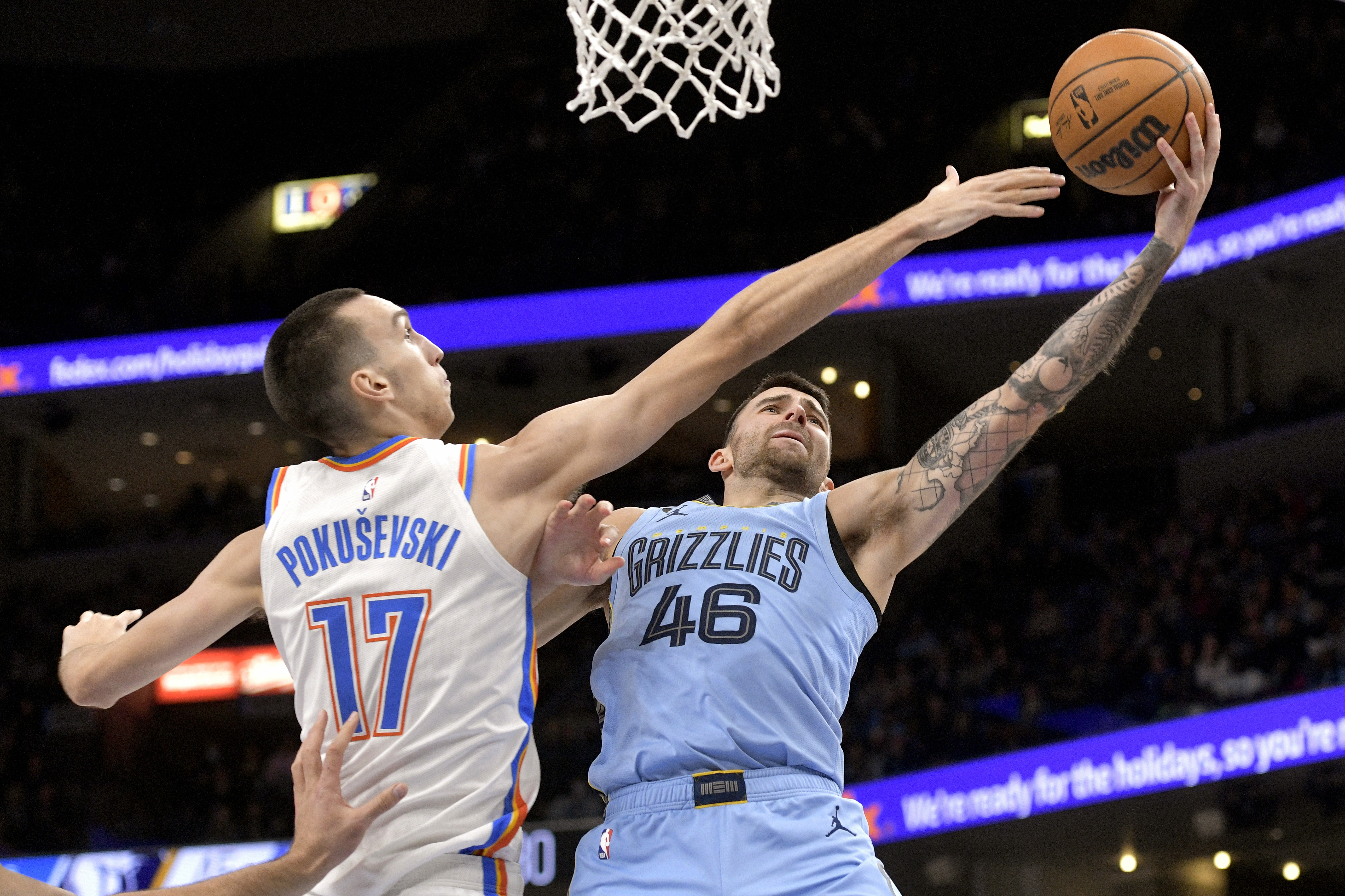 Memphis Grizzlies guard John Konchar (46) shoots against Oklahoma City Thunder forward Aleksej Pokusevski (17) in the first half of an NBA basketball game Wednesday, Dec. 7, 2022, in Memphis, Tenn. (AP Photo/Brandon Dill)