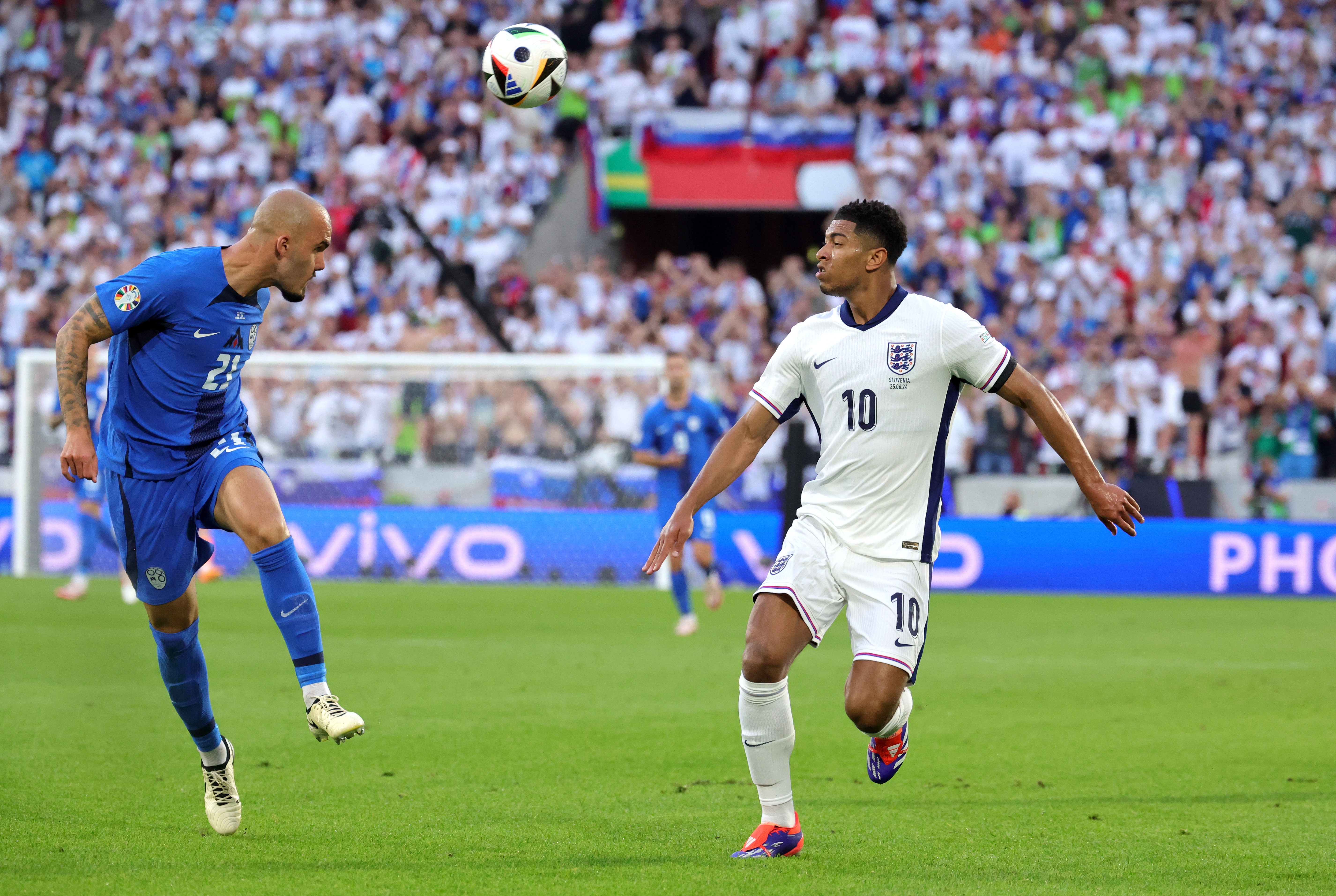 epa11437569 Jude Bellingham (R) of England and Vanja Drkusic of Slovenia in action during the UEFA EURO 2024 group C soccer match between England and Slovenia, in Cologne, Germany, 25 June 2024.  EPA-EFE/OLIVIER MATTHYS