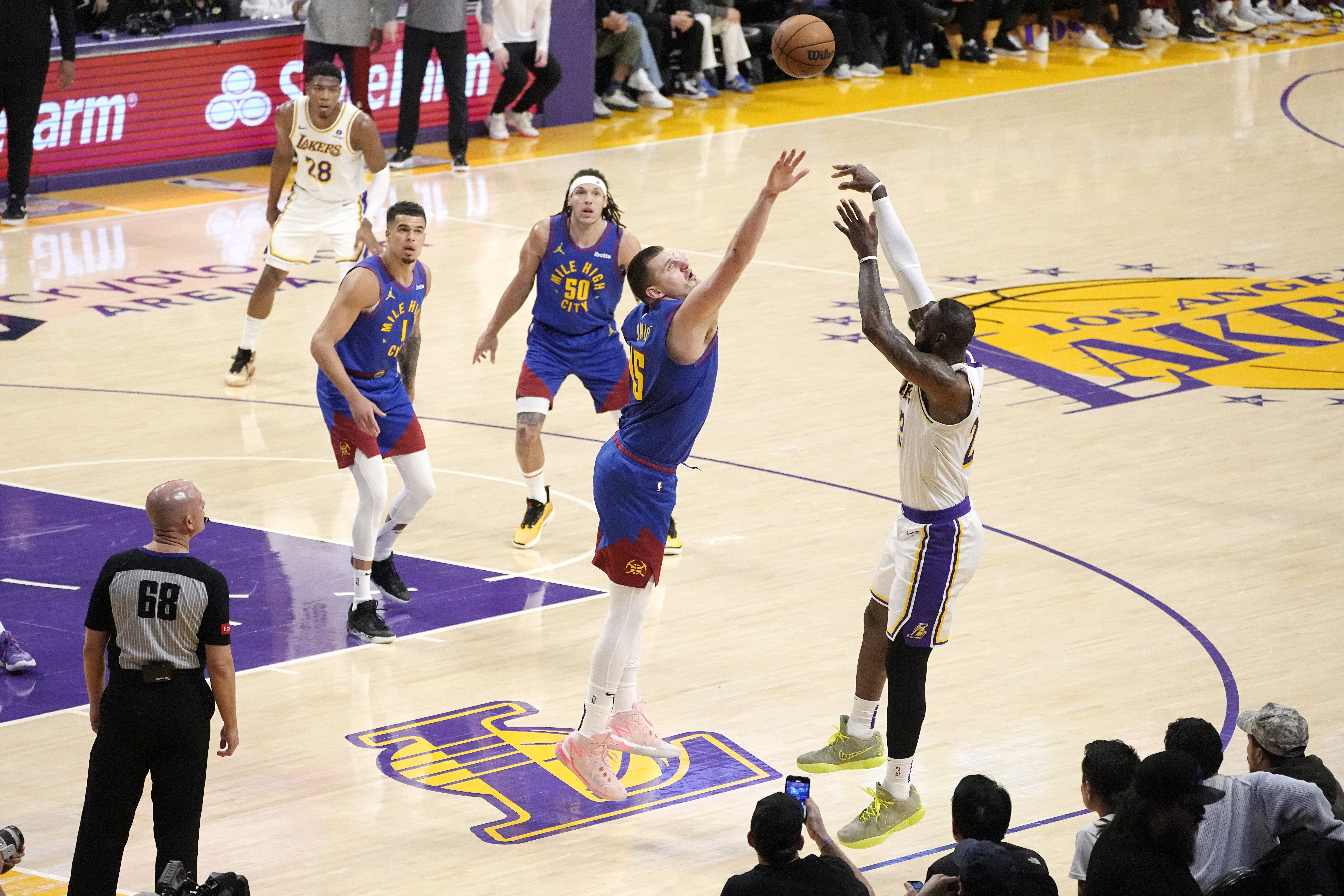 Los Angeles Lakers forward LeBron James, right, shoots as Denver Nuggets center Nikola Jokic defends during the first half of an NBA basketball game Saturday, March 2, 2024, in Los Angeles. (AP Photo/Mark J. Terrill)