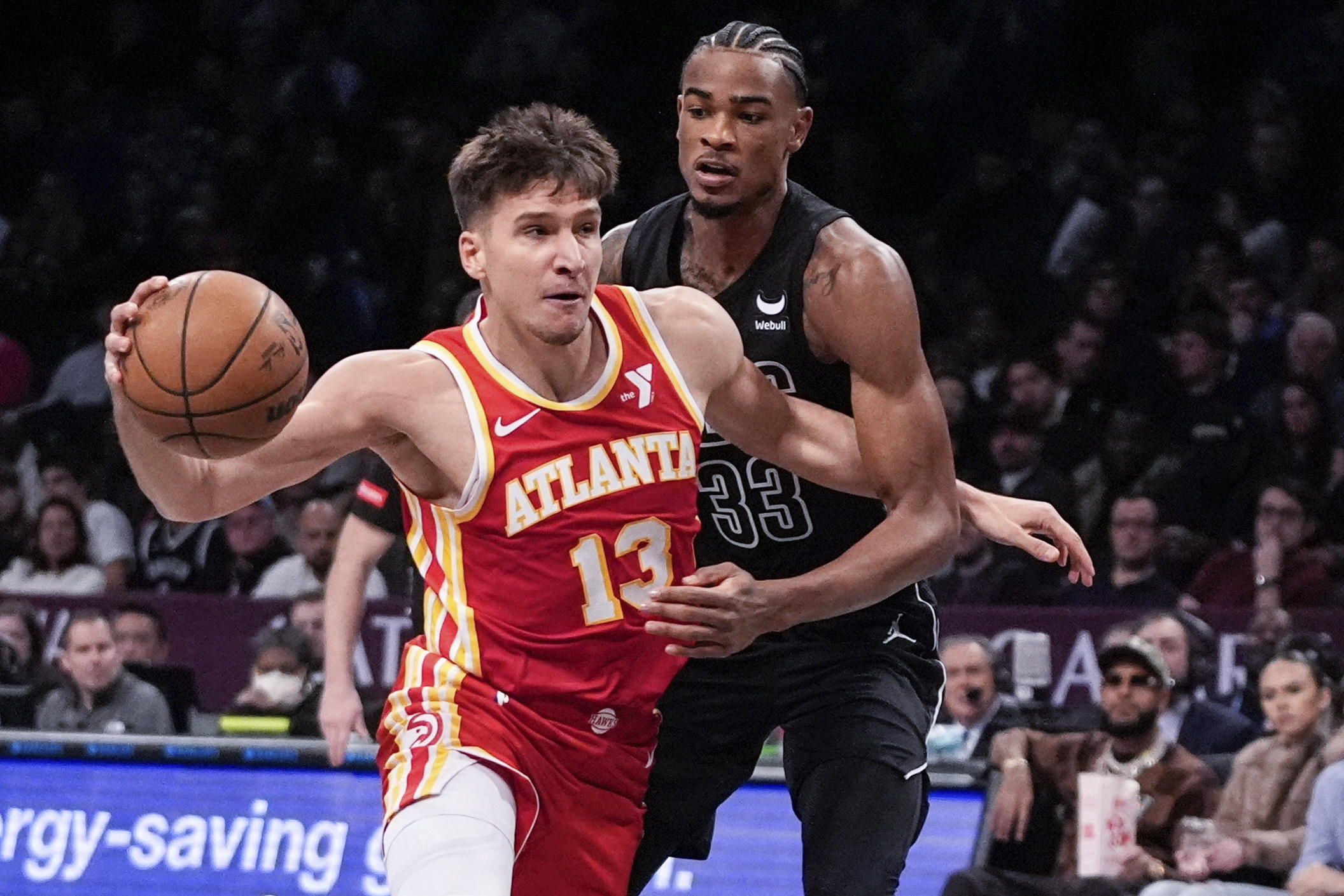 Atlanta Hawks' Bogdan Bogdanovic (13) drives past Brooklyn Nets' Nic Claxton (33) during the first half of an NBA basketball game Thursday, Feb. 29, 2024, in New York. (AP Photo/Frank Franklin II)