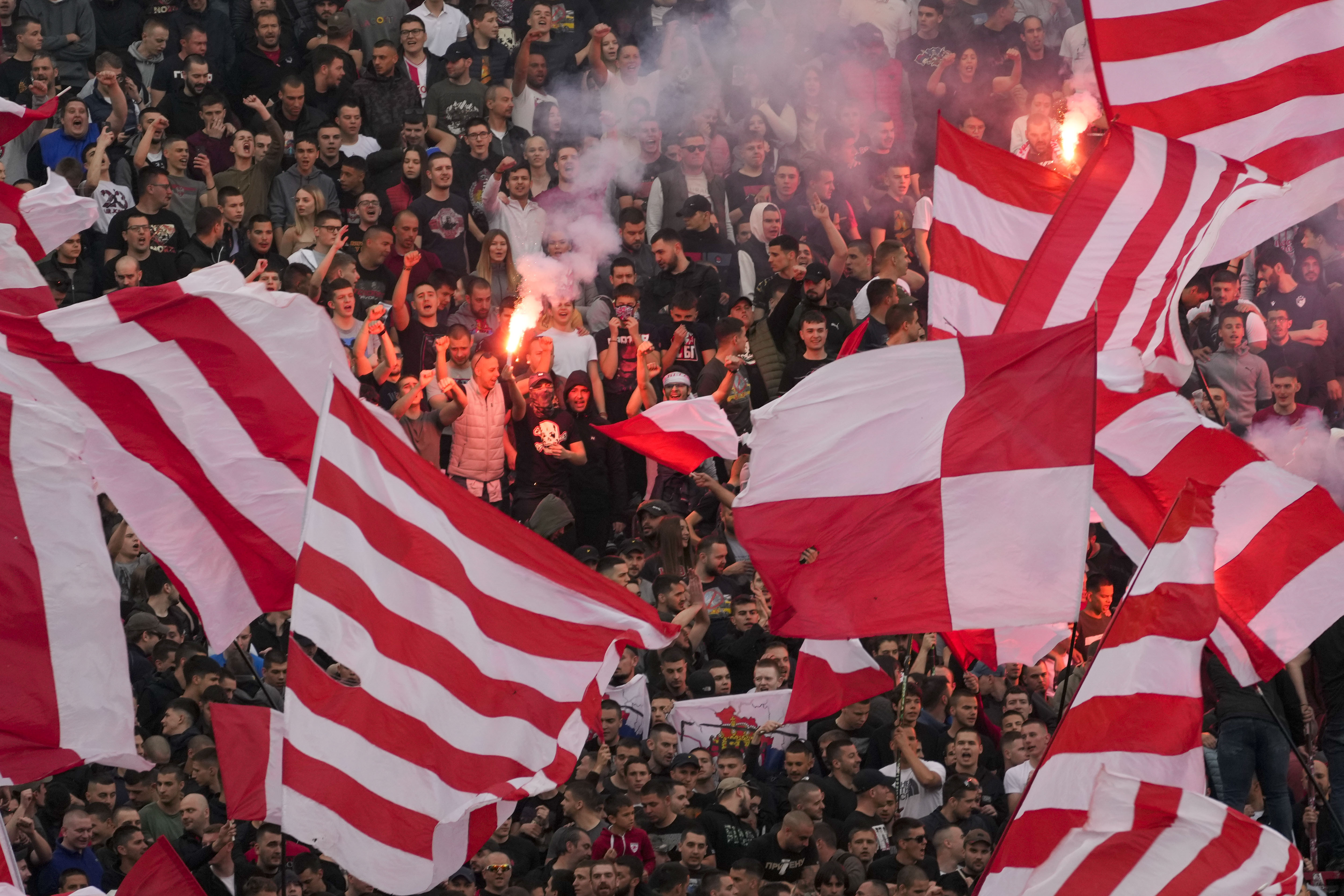 Red Star fans light pyrotechnics during a Serbian National soccer league derby match between Red Star and Partizan in Belgrade, Serbia, Saturday, April 20, 2024. (AP Photo/Darko Vojinovic)