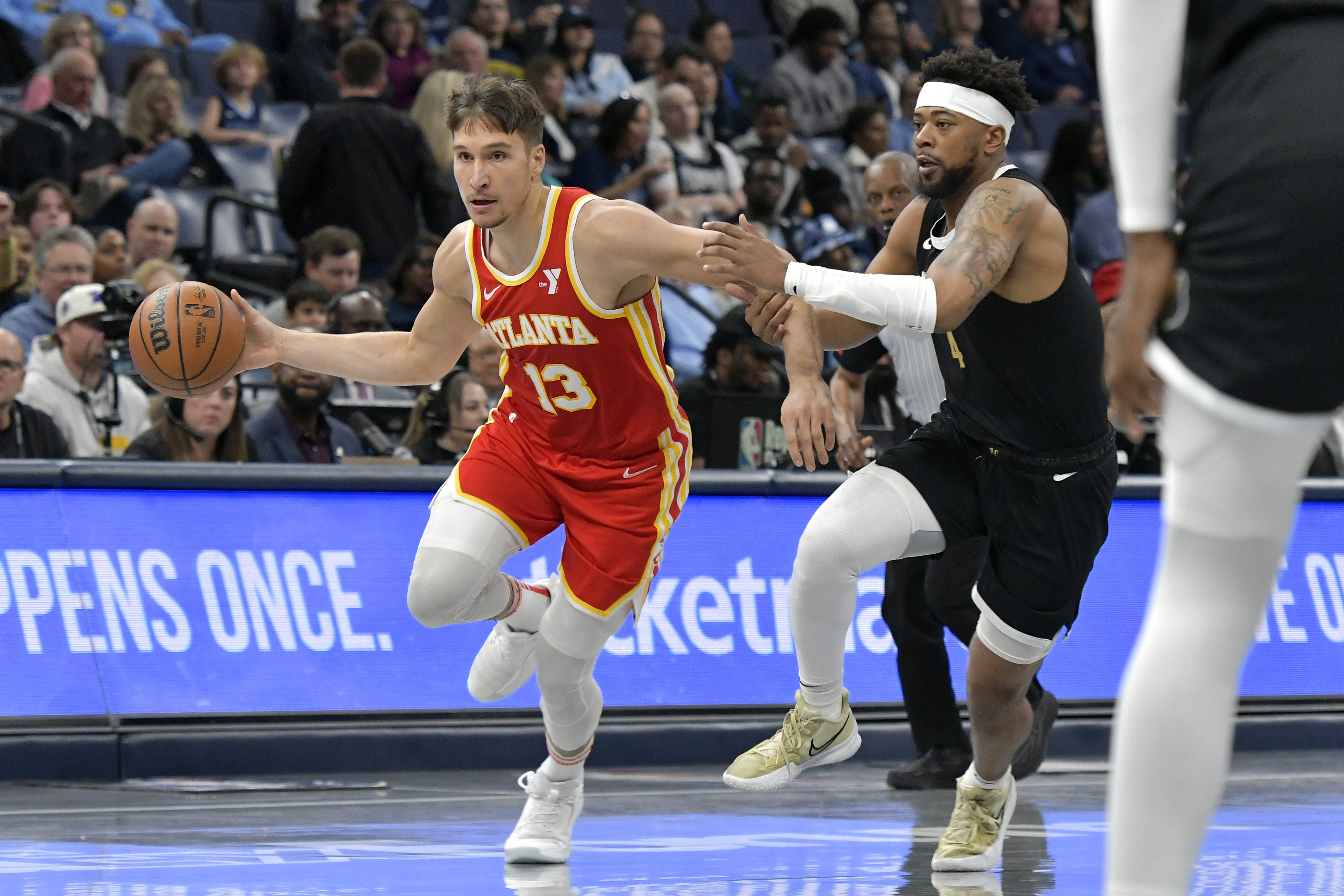 Atlanta Hawks guard Bogdan Bogdanovic (13) drives against Memphis Grizzlies guard Jordan Goodwin (4) during the first half of an NBA basketball game Friday, March 8, 2024, in Memphis, Tenn. (AP Photo/Brandon Dill)
