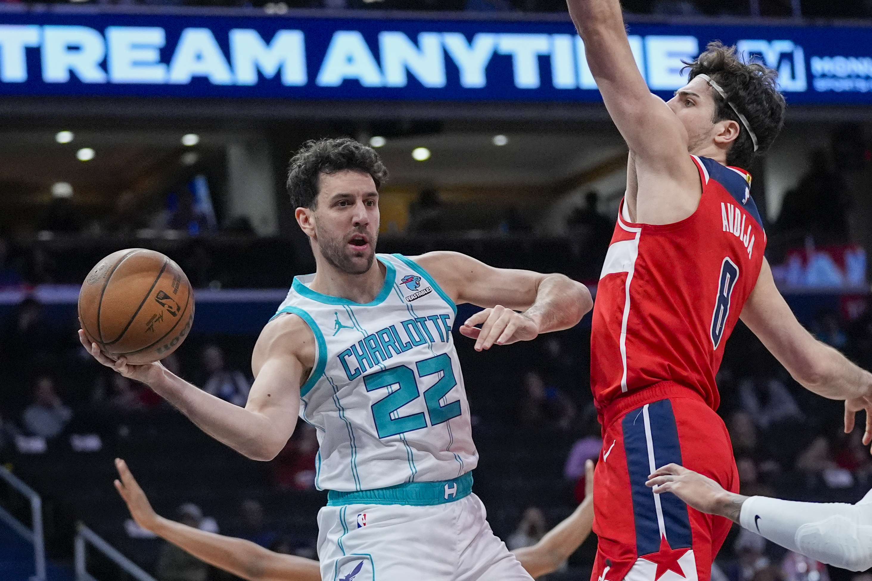 Charlotte Hornets guard Vasa Micic (22) passes the ball as Washington Wizards forward Deni Avdija (8) defends during the first half of an NBA basketball game Friday, March 8, 2024, in Washington. (AP Photo/Alex Brandon)