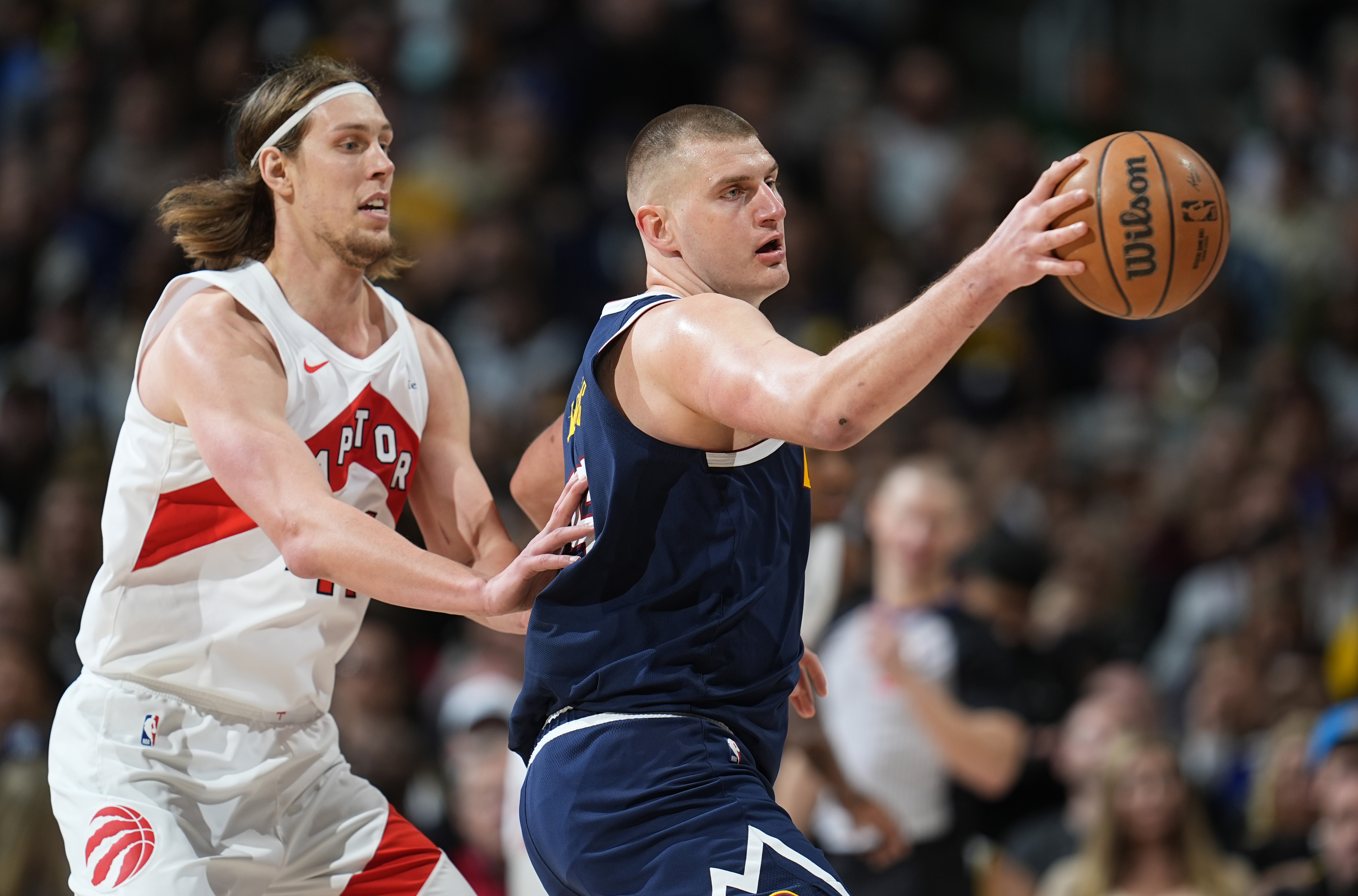 Denver Nuggets center Nikola Jokic, right, fields a pass as Toronto Raptors forward Kelly Olynyk, left, defends in the second half of an NBA basketball game Monday, March 11, 2024, in Denver. (AP Photo/David Zalubowski)