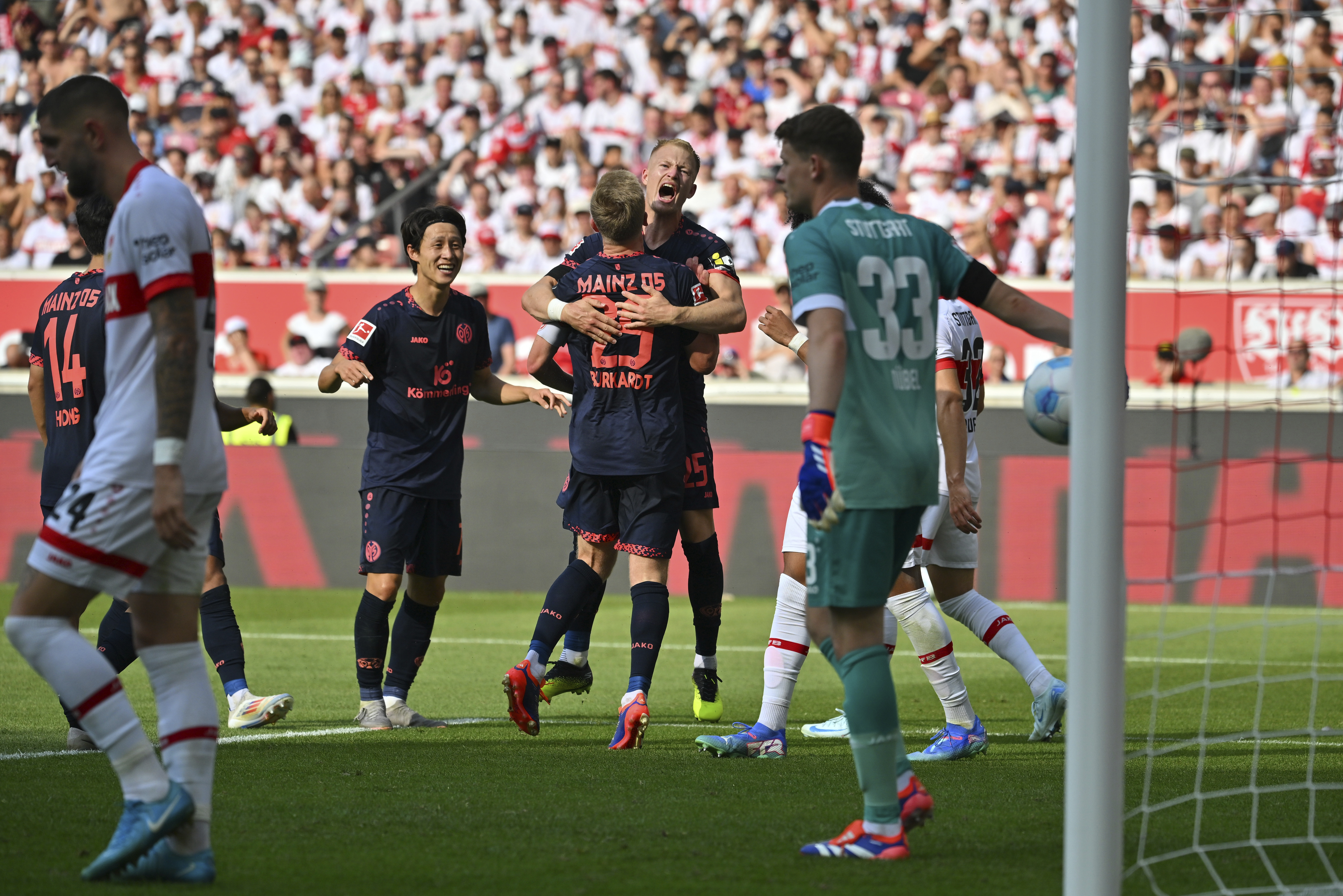 Mainz players celebrate their second goal by Jonathan Burkardt, centre back to the camera, during the German Bundesliga soccer match between Stuttgart and Mainz in Stuttgart, Germany, Saturday, Aug. 31, 2024. (Jan-Philipp Strobel/dpa via AP)