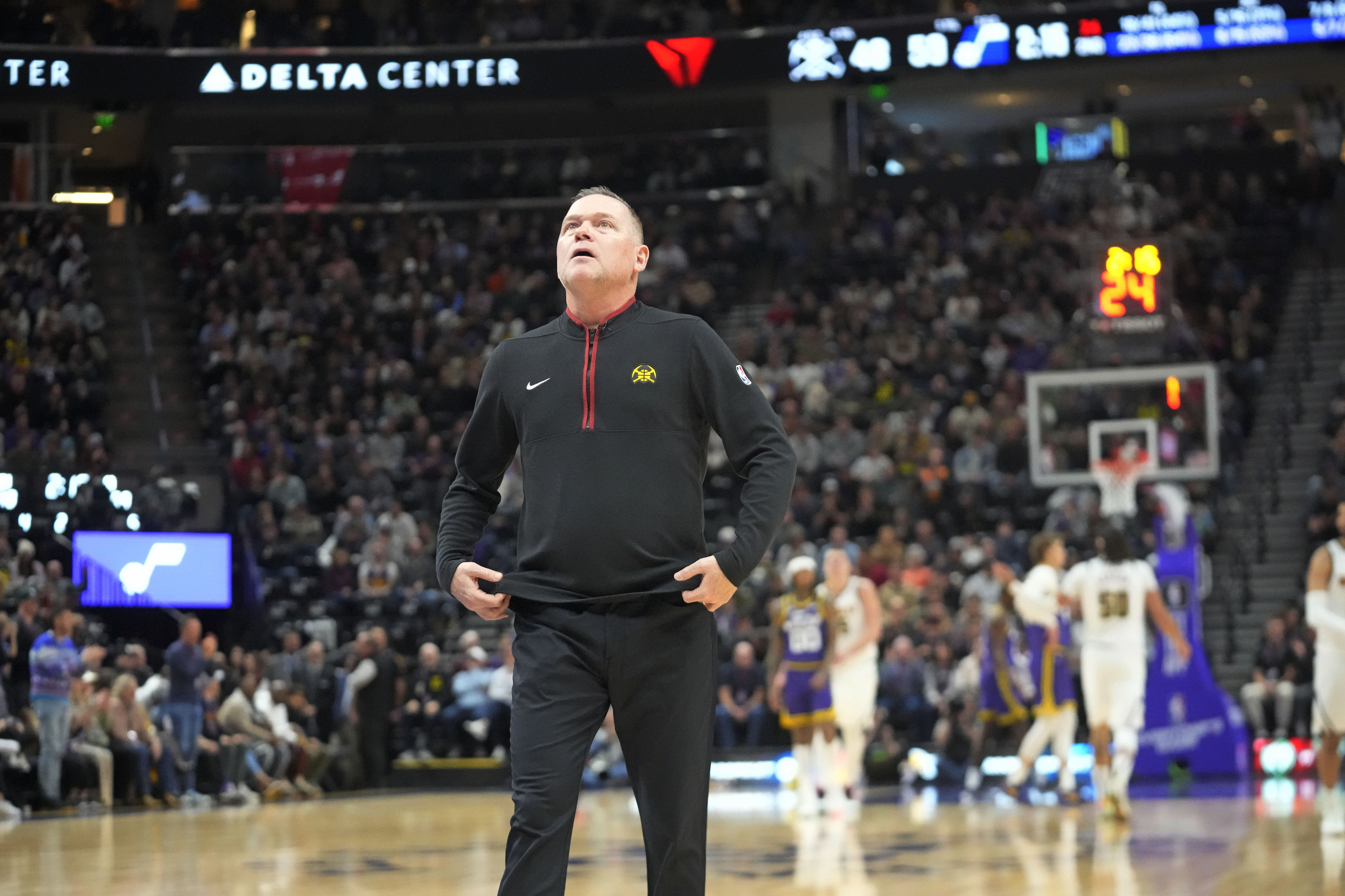 Denver Nuggets coach Michael Malone looks at the scoreboard during a timeout in the first half of the team's NBA basketball game against the Utah Jazz on Wednesday, Jan. 10, 2024, in Salt Lake City. (AP Photo/Rick Bowmer)