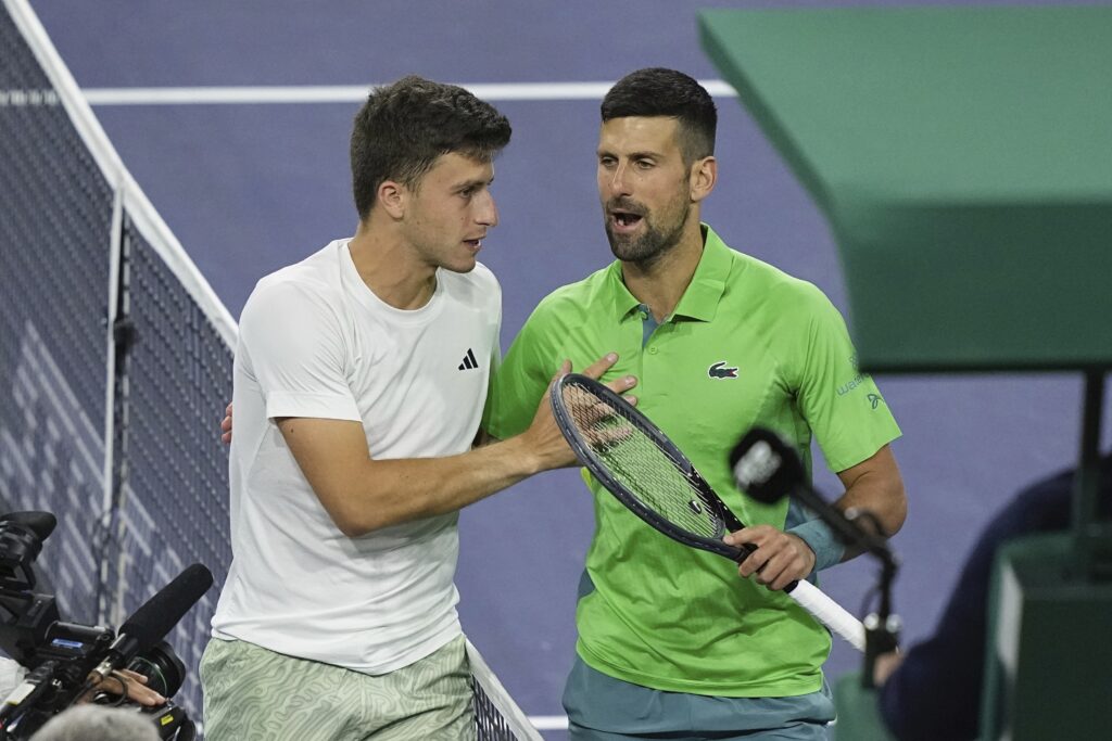 Luca Nardi, of Italy, talks with Novak Djokovic, of Serbia, after upsetting Djokovic at the BNP Paribas Open tennis tournament Monday, March 11, 2024, in Indian Wells, Calif. Nardi won 6-4, 3-6, 6-3. (AP Photo/Mark J. Terrill)