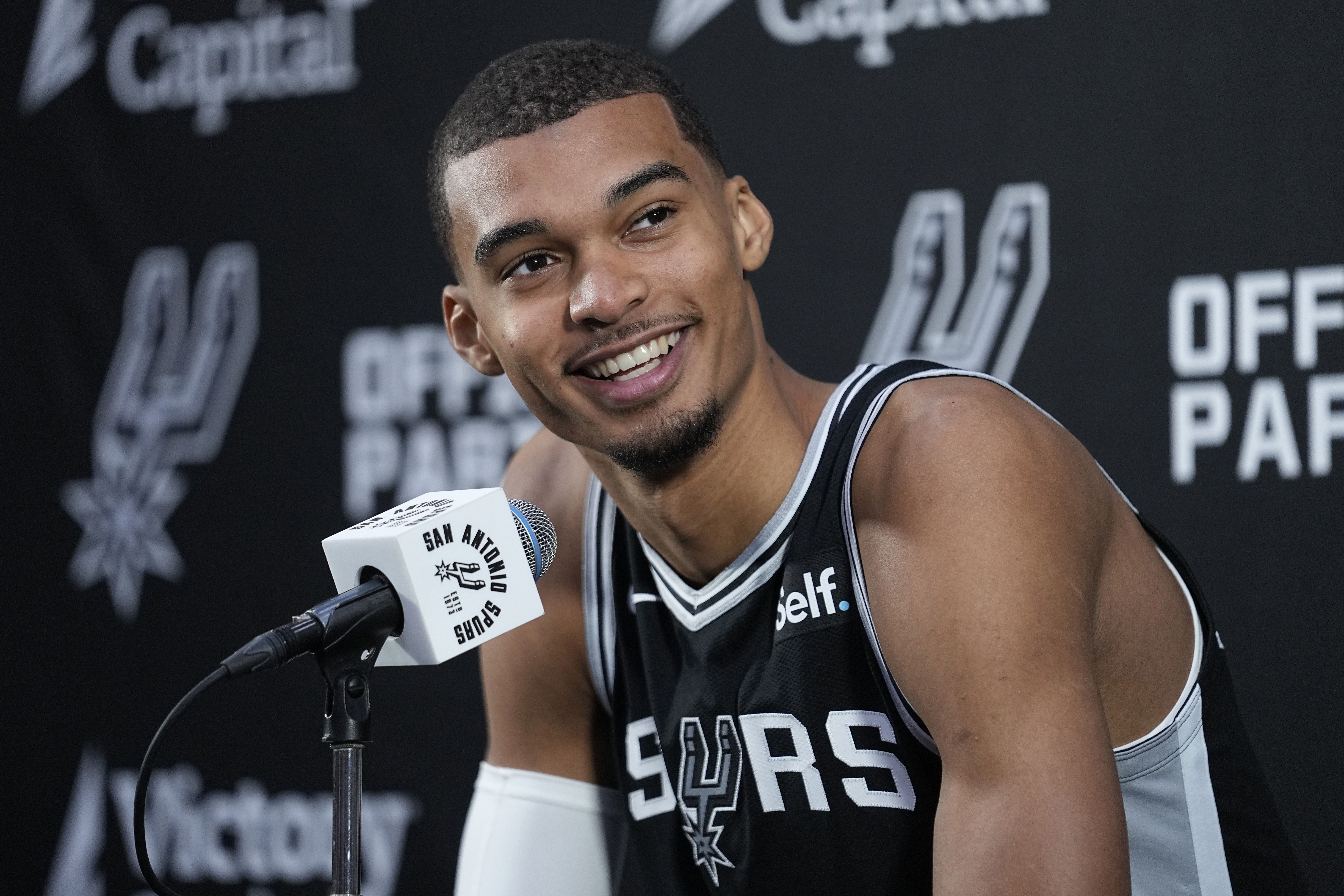San Antonio Spurs center Victor Wembanyama, the NBA's first round draft pick, center, talks to the media during an NBA basketball media day in San Antonio, Monday, Oct. 2, 2023. (AP Photo/Eric Gay)