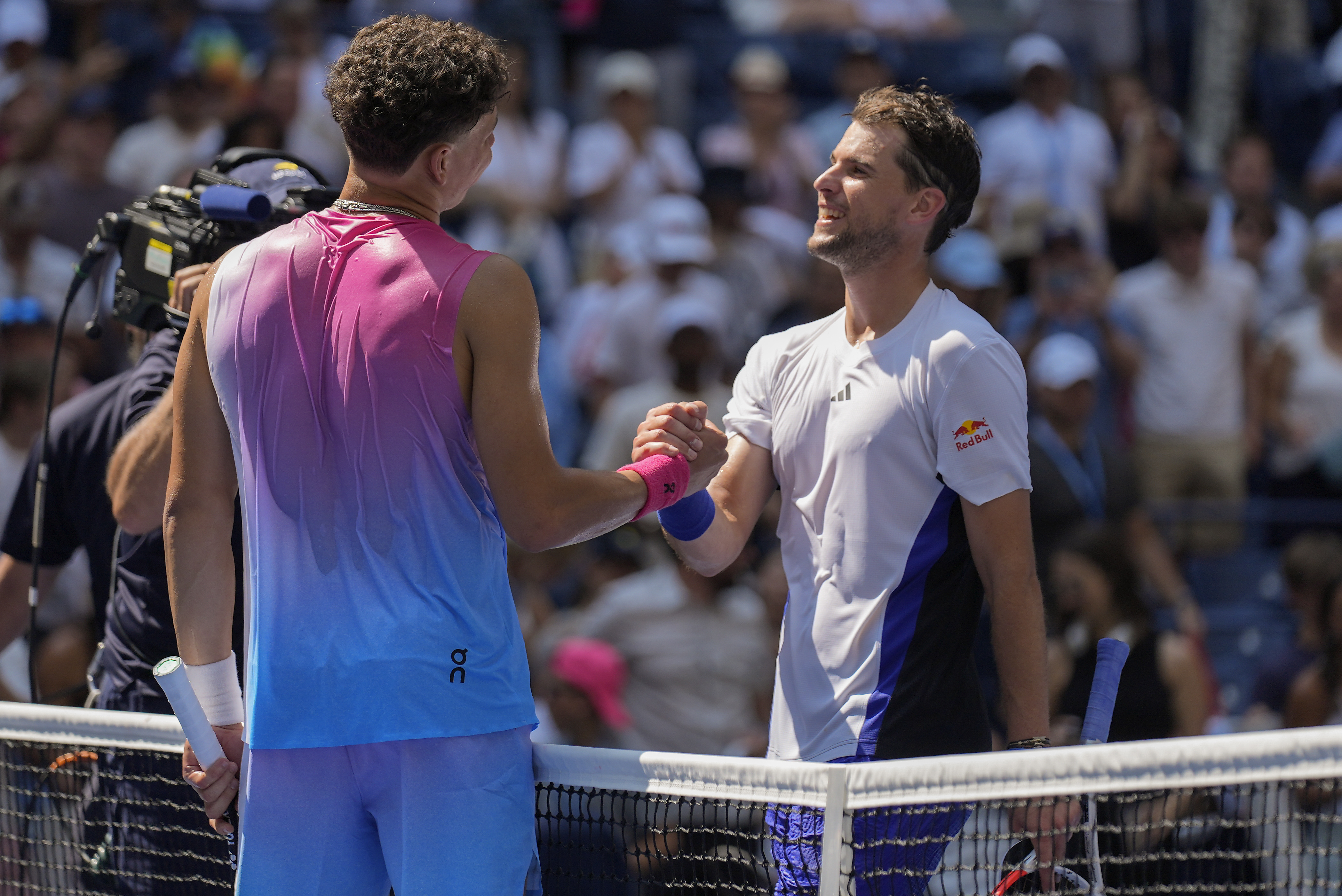 Ben Shelton, of the United States, left, shakes hands with Dominic Thiem, of Austria, after winning their first round match of the U.S. Open tennis championships, Monday, Aug. 26, 2024, in New York. (AP Photo/Seth Wenig)