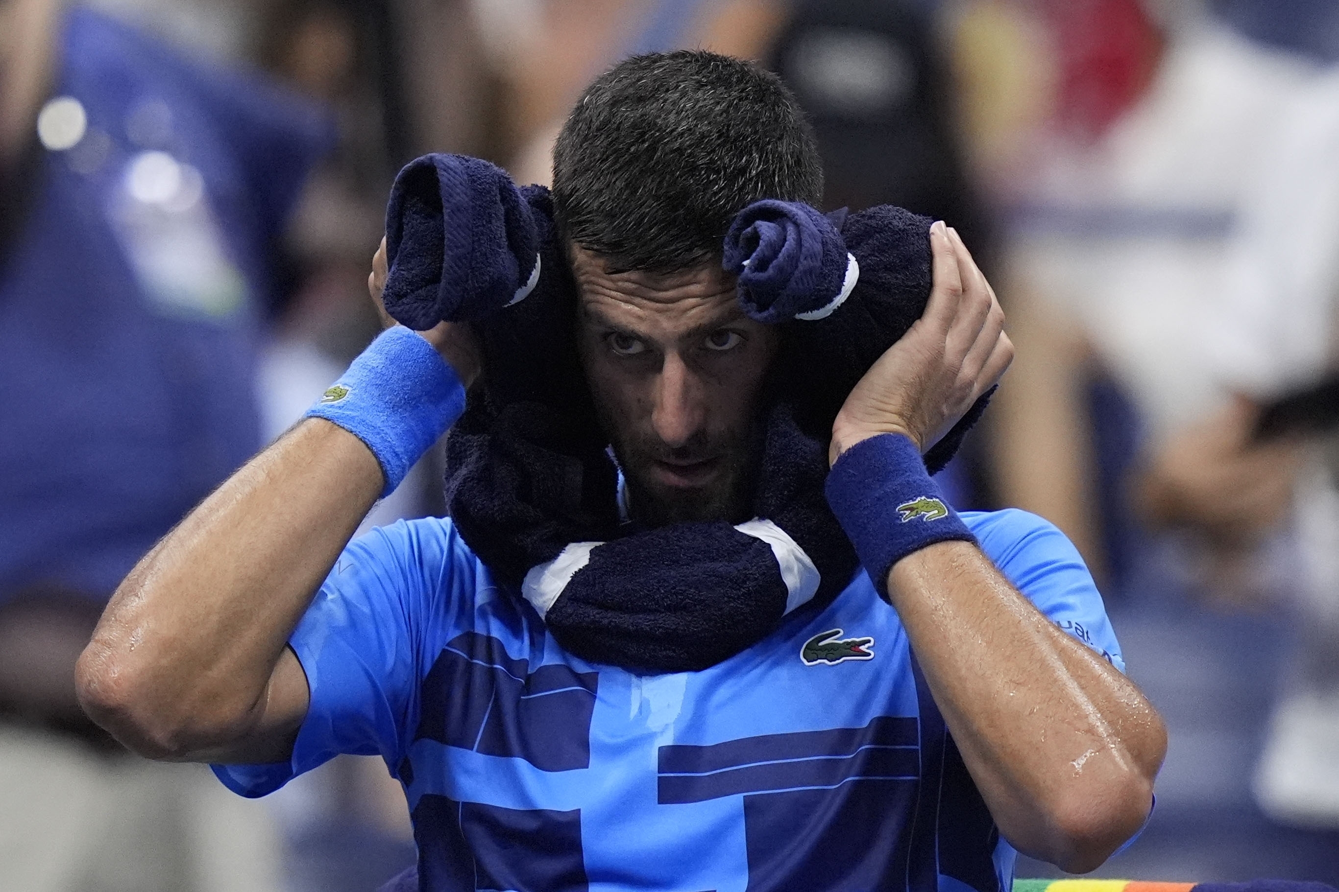 Novak Djokovic, of Serbia, puts a towel around his neck during a second round match against Laslo Djere, of Serbia, of the U.S. Open tennis championships, Wednesday, Aug. 28, 2024, in New York. (AP Photo/Frank Franklin II)