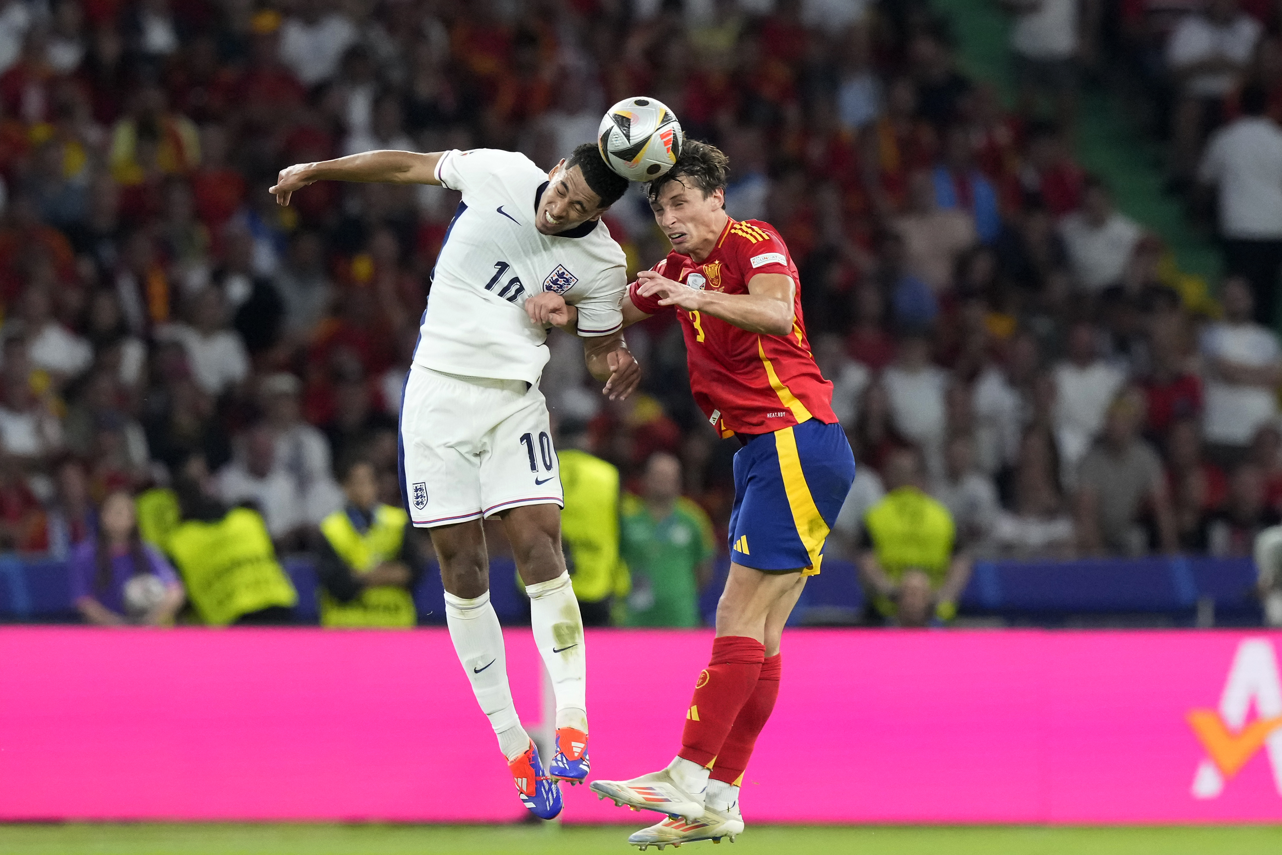 Spain's Robin Le Normand, right, jumps for the ball with England's Jude Bellingham during the final match between Spain and England at the Euro 2024 soccer tournament in Berlin, Germany, Sunday, July 14, 2024. (AP Photo/Frank Augstein)