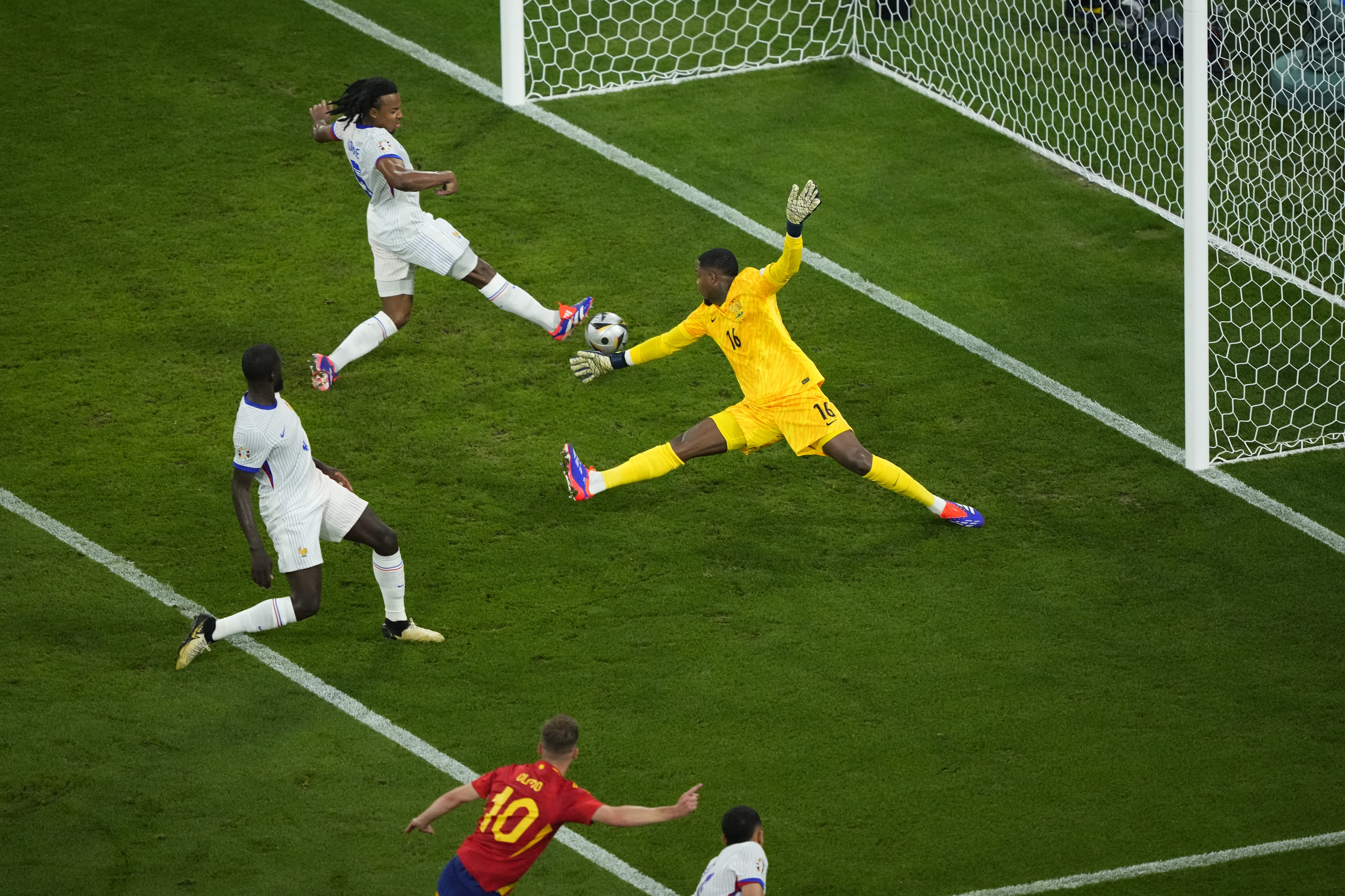 Jules Kounde of France, top, scores an own goal to give Spain a 2-1 lead during a semifinal match between Spain and France at the Euro 2024 soccer tournament in Munich, Germany, Tuesday, July 9, 2024. (AP Photo/Ebrahim Noroozi)