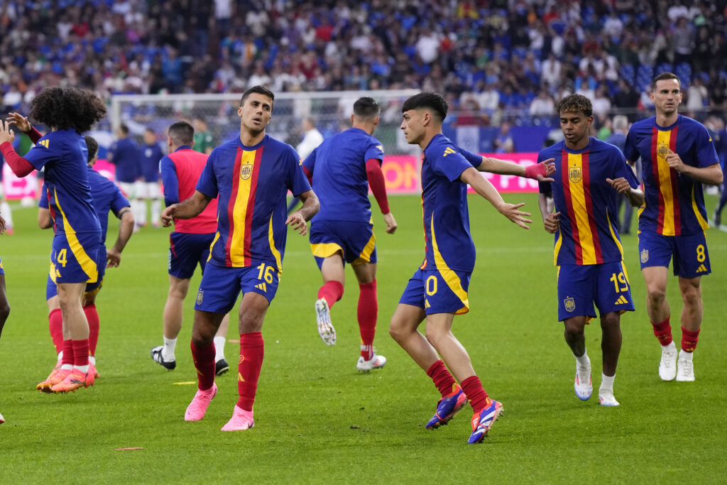 Spain's Rodri (16), Pedri (20), Lamine Yamal (19) and Fabian Ruiz (8) warm up before a Group B match between Spain and Italy at the Euro 2024 soccer tournament in Gelsenkirchen, Germany, Thursday, June 20, 2024. (AP Photo/Manu Fernandez)