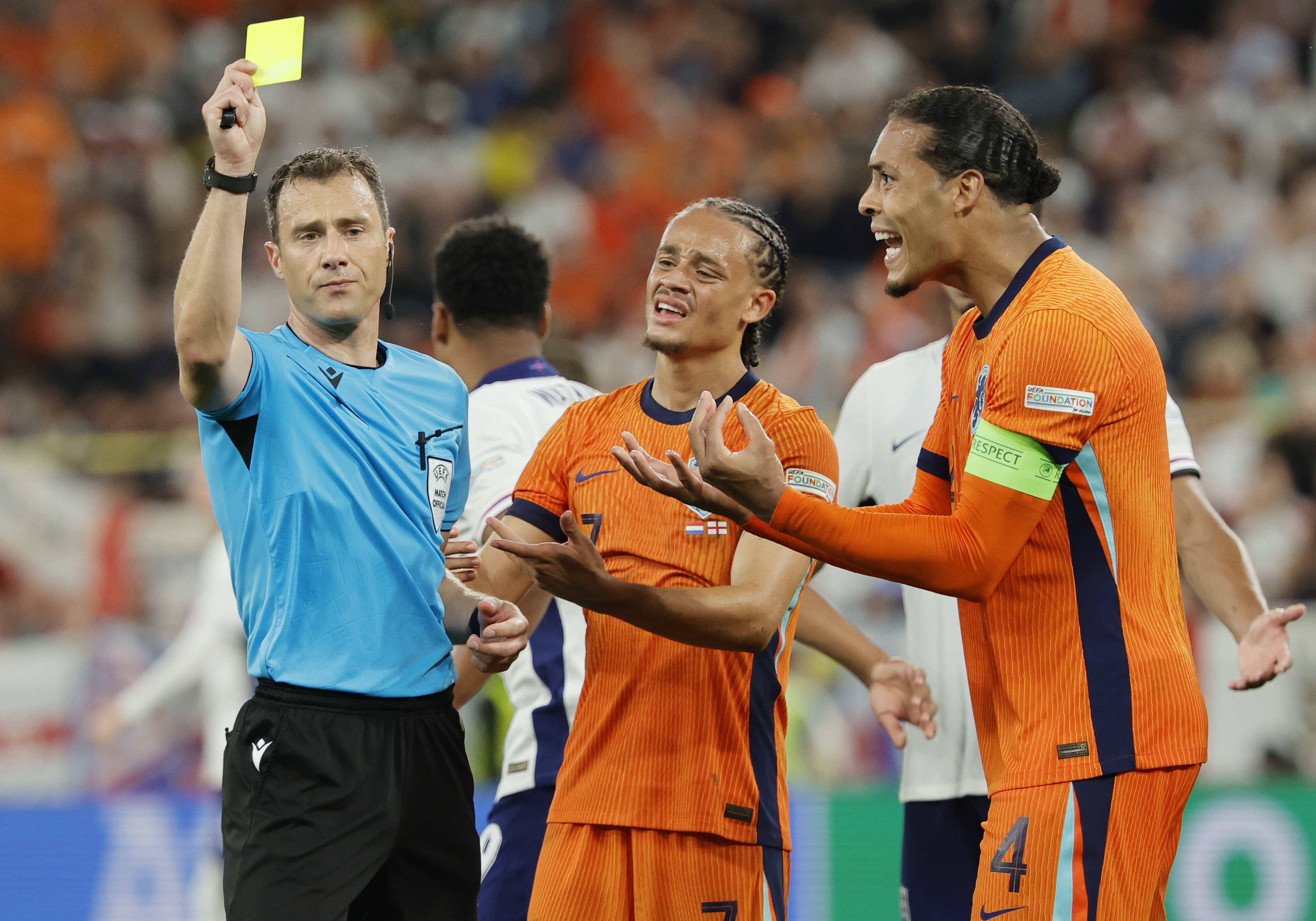 epa11471376 Referee Felix Zwayer (L) shows a yellow card to Virgil van Dijk of Netherlands (R) the UEFA EURO 2024 semi-finals soccer match between Netherlands and England, in Dortmund, Germany, 10 July 2024.  EPA-EFE/RONALD WITTEK