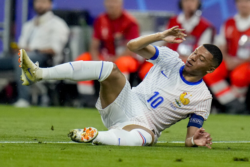 Kylian Mbappe of France lies on the pitch during a semifinal match between Spain and France at the Euro 2024 soccer tournament in Munich, Germany, Tuesday, July 9, 2024. Left Spain's Rodri. (AP Photo/Hassan Ammar)