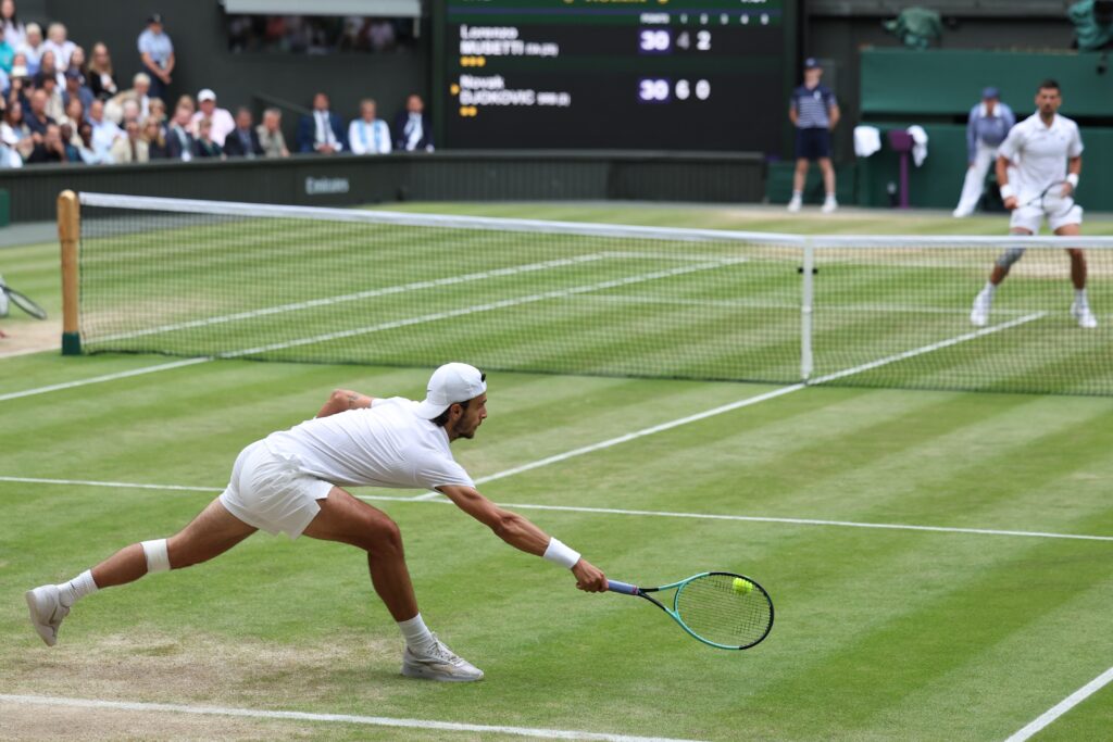 epa11474765 Lorenzo Musetti of Italy in action during his Men's Singles semifinal match against Novak Djokovic of Serbia at the Wimbledon Championships, Wimbledon, Britain, 12 July 2024.  EPA-EFE/NEIL HALL  EDITORIAL USE ONLY