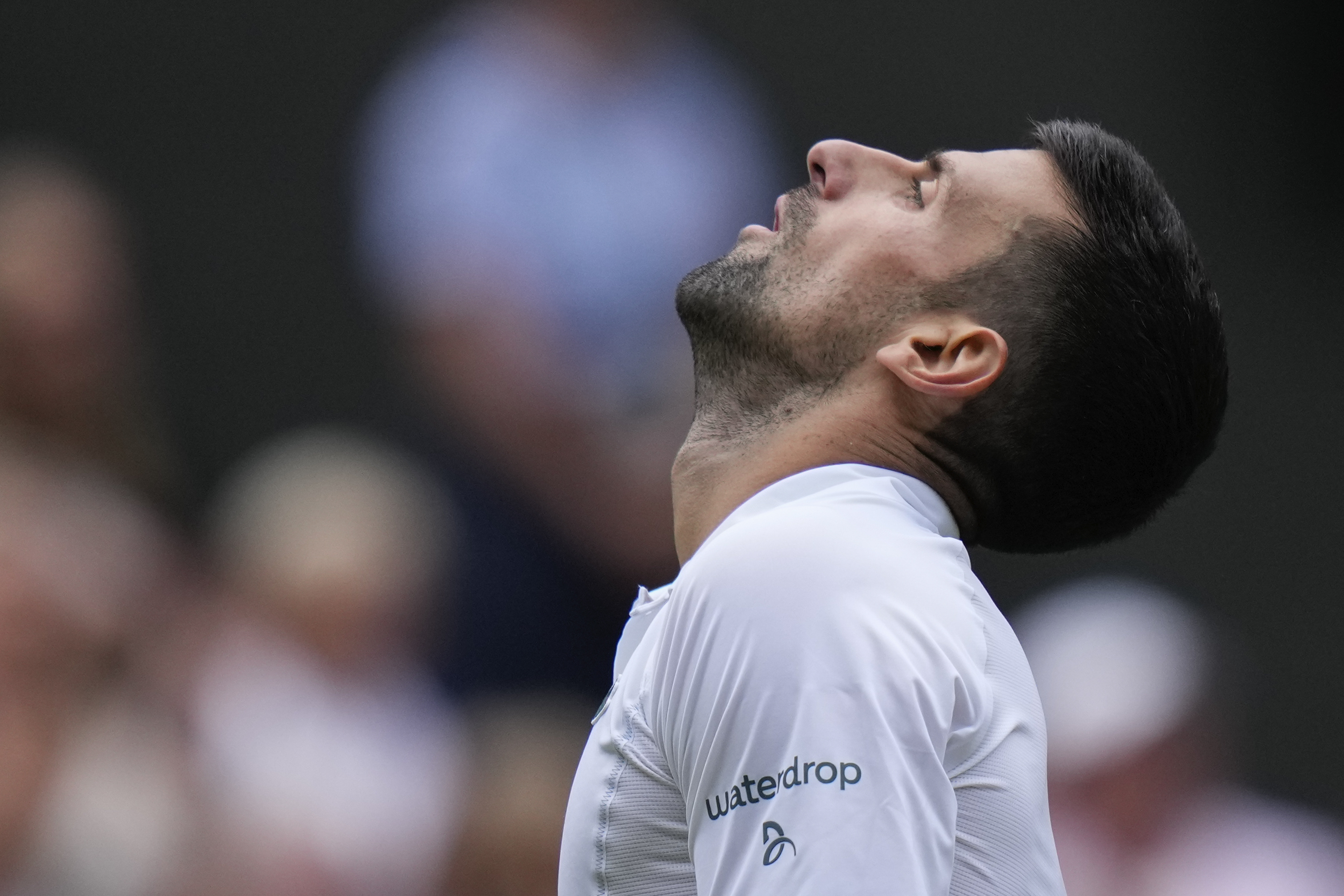 Novak Djokovic of Serbia reacts during his semifinal match against Lorenzo Musetti of Italy at the Wimbledon tennis championships in London, Friday, July 12, 2024. (AP Photo/Alberto Pezzali)
