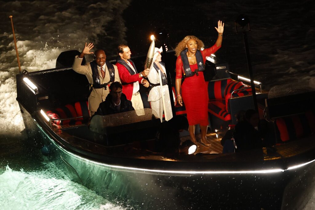 epa11498141 The Olympic torch is being taken down the Seine in a boat with (L-R) Carl Lewis, Rafael Nadal, Nadia Comaneci and Serena Williams during the Opening Ceremony of the Paris 2024 Olympic Games, in Paris, France, 26 July 2024.  EPA-EFE/YOAN VALAT