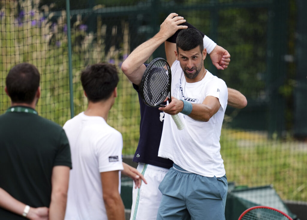Serbia's Novak Djokovic stretches during a training session at the All England Lawn Tennis and Croquet Club in Wimbledon ahead of the Wimbledon tennis tournament, Monday June 24, 2024. (John Walton/PA via AP)