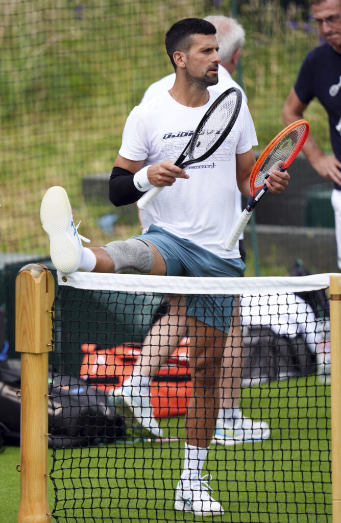 Serbia's Novak Djokovic stretches during a training session at the All England Lawn Tennis and Croquet Club in Wimbledon ahead of the Wimbledon Championships, which begins on July 1st, in London, Monday June 24, 2024. (John Walton/PA via AP)