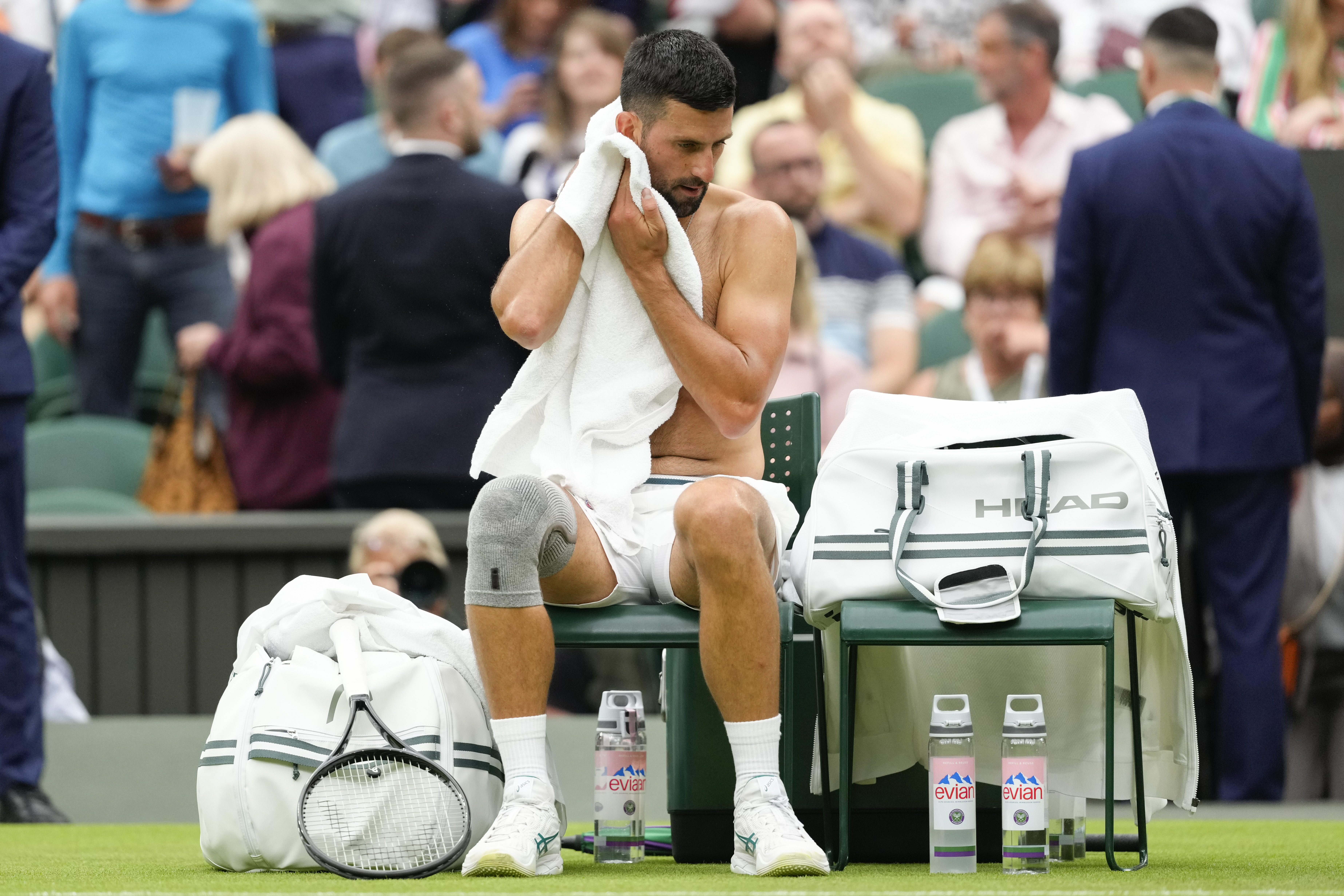 Serbia's Novak Djokovic wipes the sweat from his face during a break I his first round match against Vit Kopriva of the Czech Republic at the Wimbledon tennis championships in London, Tuesday, July 2, 2024. (AP Photo/Kirsty Wigglesworth)