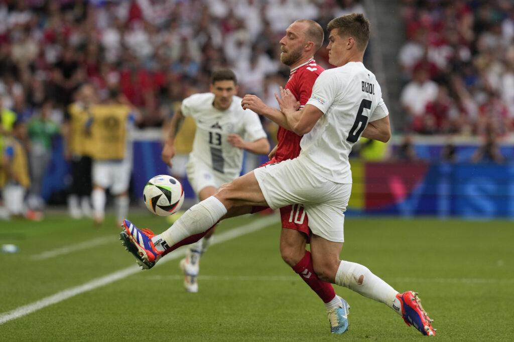 Slovenia's Jaka Bijol, front, and Denmark's Christian Eriksen compete for the ball during a Group C match between Slovenia and Denmark at the Euro 2024 soccer tournament in Stuttgart, Germany, Sunday, June 16, 2024. (AP Photo/Antonio Calanni)