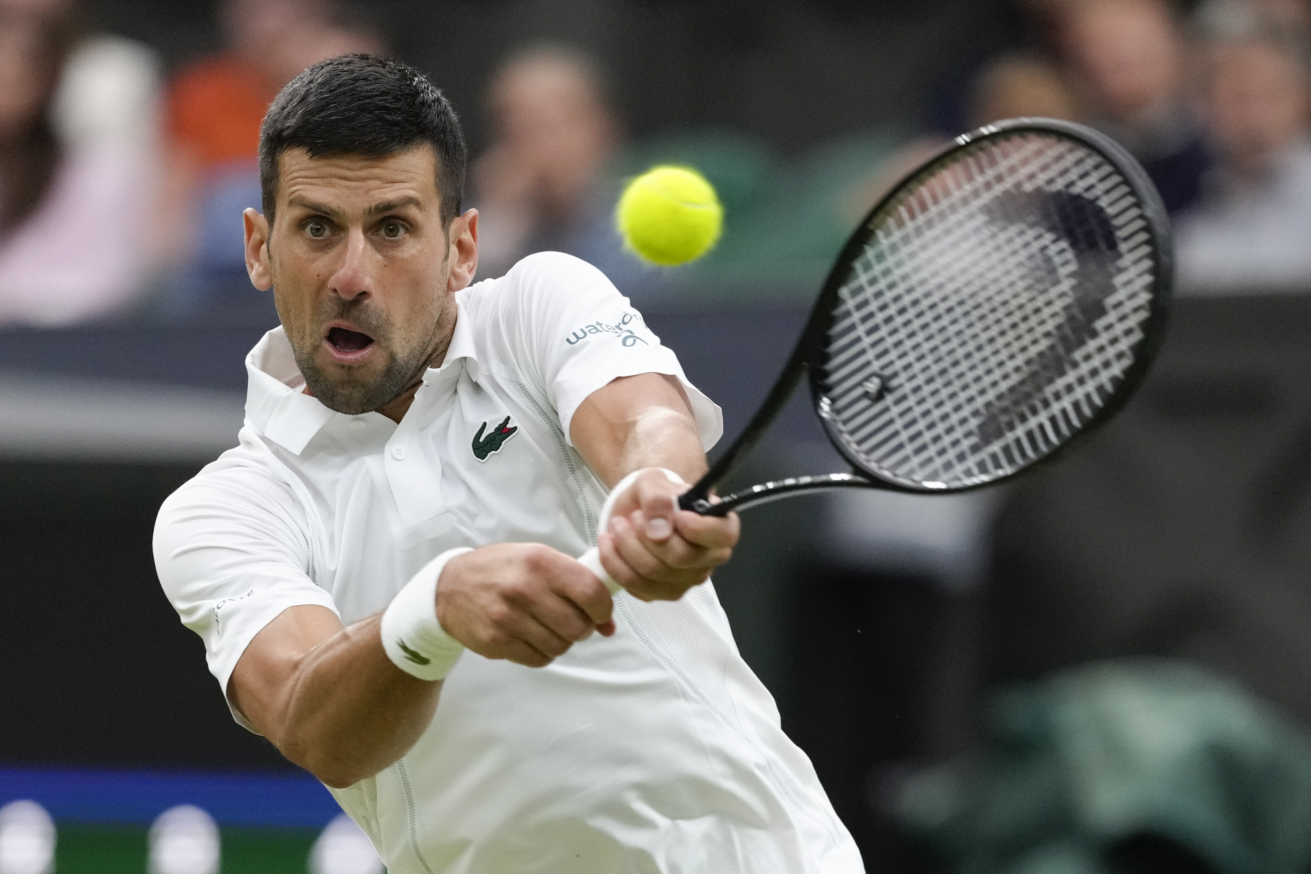 Novak Djokovic of Serbia plays a backhand return to Alexei Popyrin of Australia during their third round match at the Wimbledon tennis championships in London, Saturday, July 6, 2024. (AP Photo/Kirsty Wigglesworth)