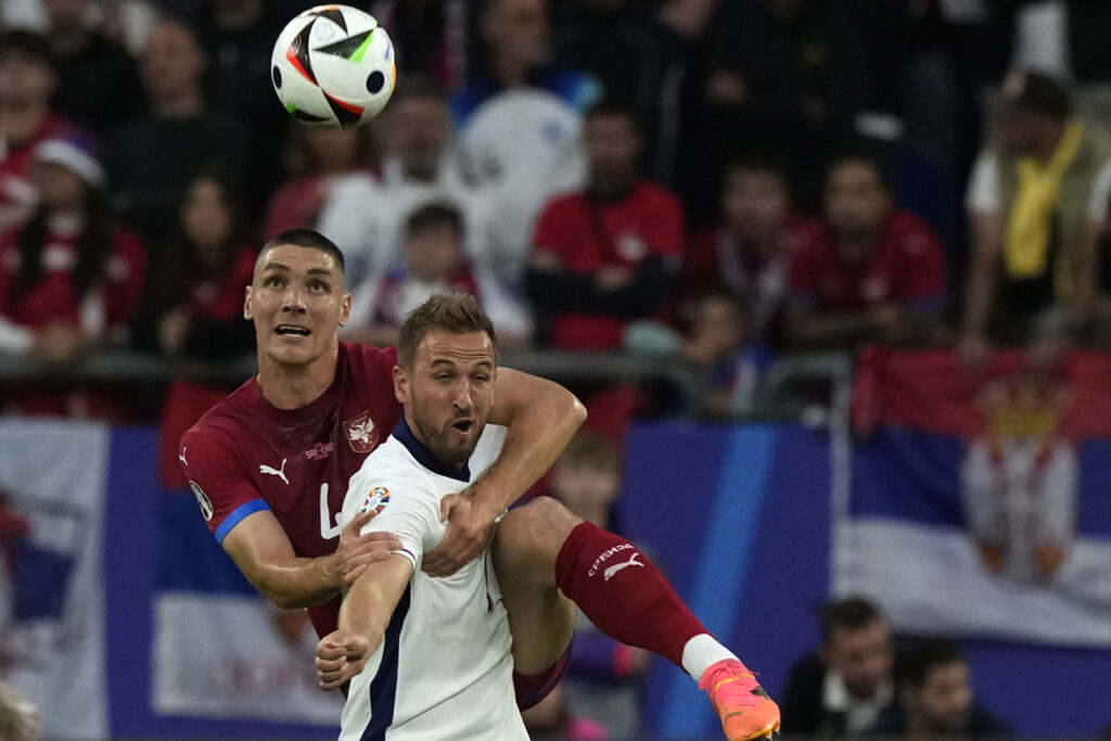 England's Harry Kane, front, tussles for the ball with Serbia's Nikola Milenkovic during a Group C match between Serbia and England at the Euro 2024 soccer tournament in Gelsenkirchen, Germany, Sunday, June 16, 2024. (AP Photo/Frank Augstein)