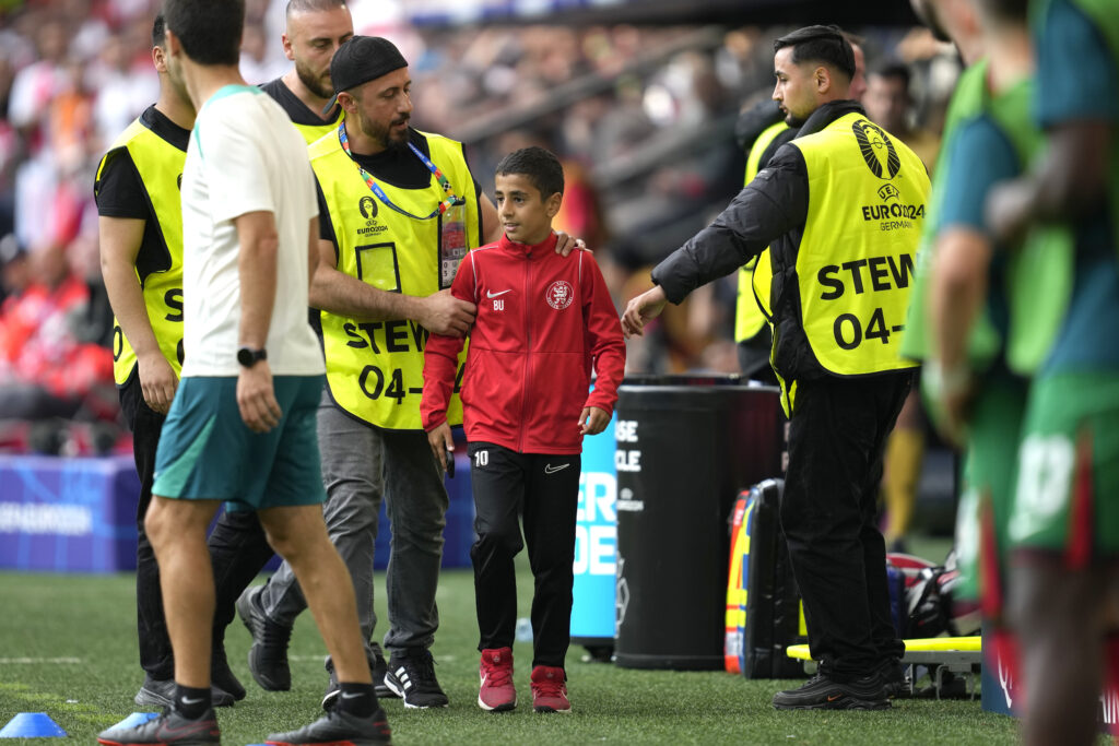 Stewards catch a young pitch invader who ran to Portugal's Cristiano Ronaldo during a Group F match between Turkey and Portugal at the Euro 2024 soccer tournament in Dortmund, Germany, Saturday, June 22, 2024. (AP Photo/Darko Vojinovic)
