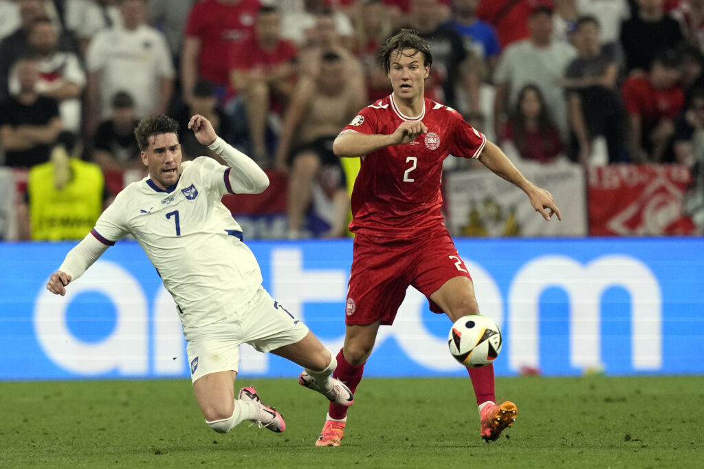 Serbia's Dusan Vlahovic (7) and Denmark's Joachim Andersen (2) battle for the ball during a Group C match between Denmark and Serbia at the Euro 2024 soccer tournament in Munich, Germany, Tuesday, June 25, 2024. (AP Photo/Antonio Calanni)