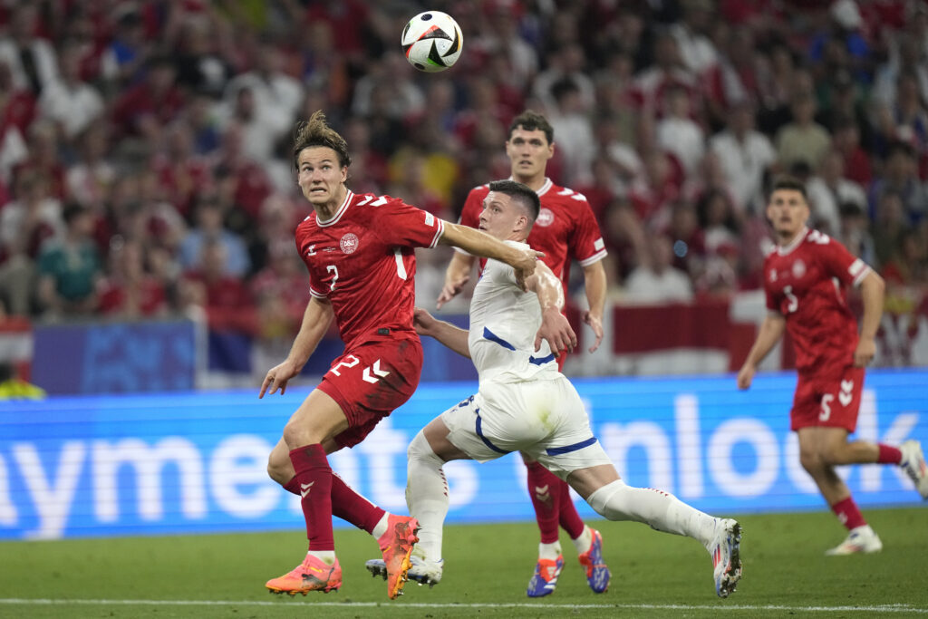 Serbia's Luka Jovic, center, fights for the ball against Denmark's Joachim Andersen, left, during a Group C match between Denmark and Serbia at the Euro 2024 soccer tournament in Munich, Germany, Tuesday, June 25, 2024. (AP Photo/Matthias Schrader)